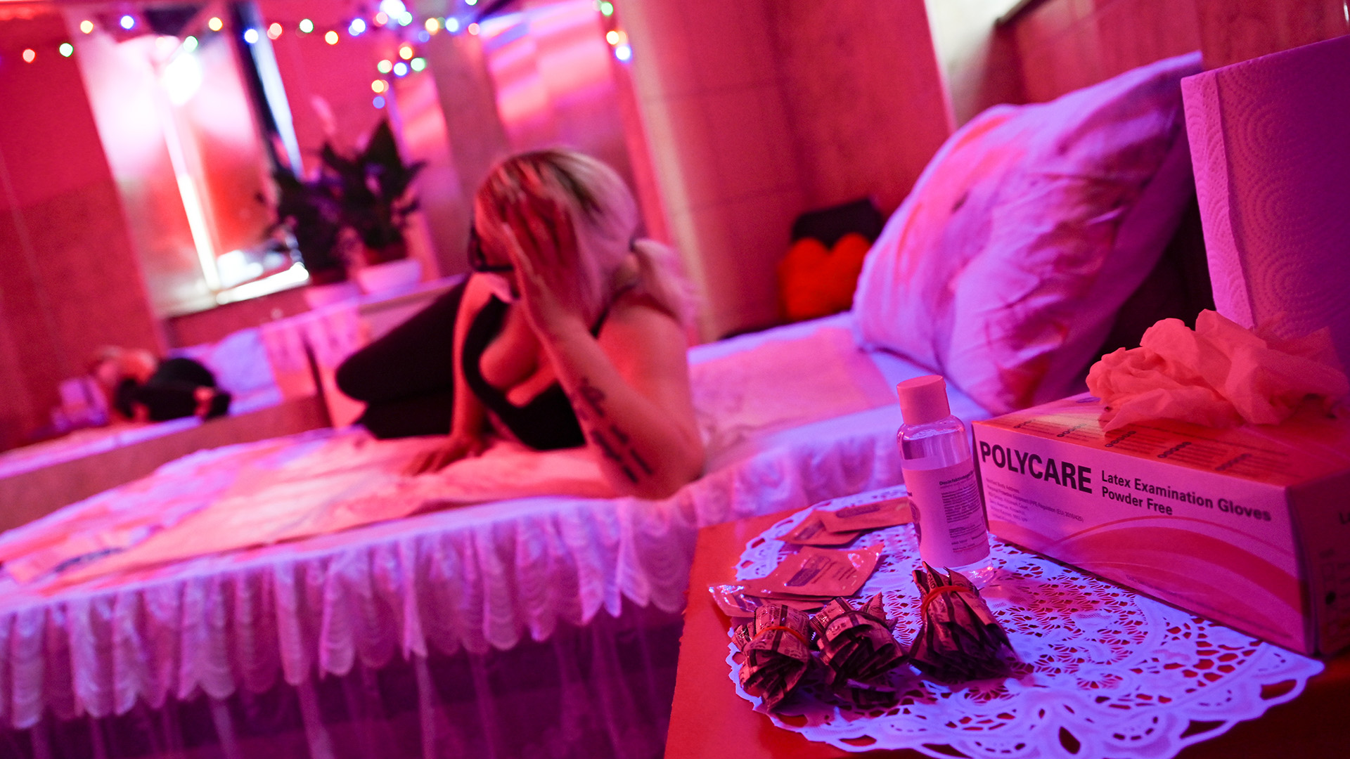 Eine Sexarbeiterin liegt in einem Zimmer des Laufhauses "Sex Inn" im Frankfurter Bahnhofsviertel auf einem Bett | dpa