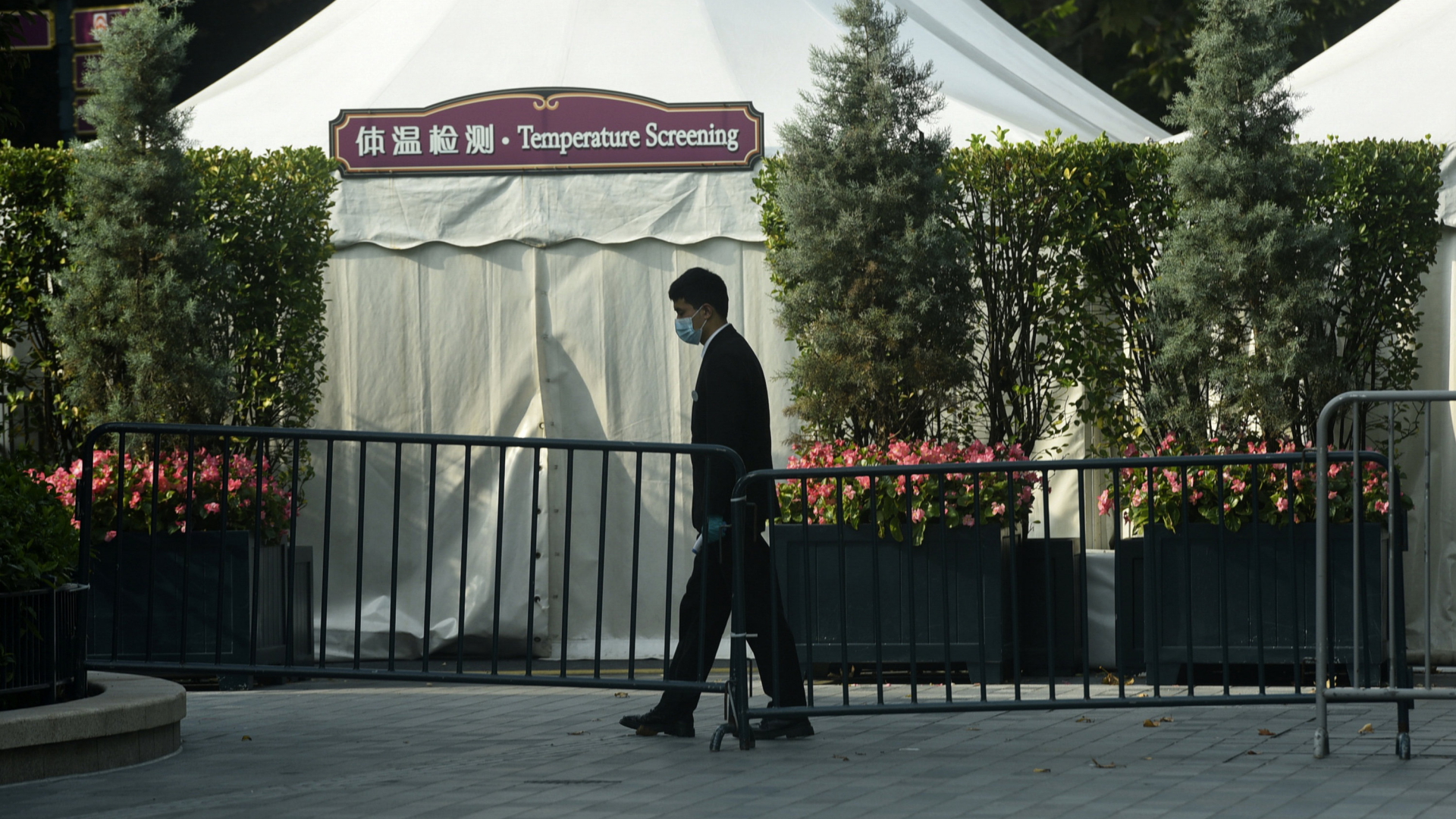 Ein Mitarbeiter läuft an eine geschlossenen Station für Temperatur-Messung in Disneyland Shanghai vorbei | AP
