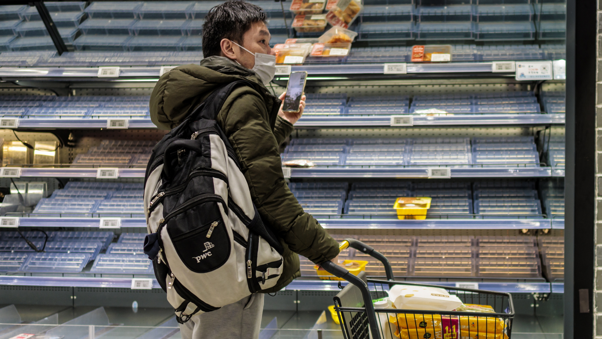Ein Mann geht durch einen Supermarkt mit leeren Regalen in Shanghai. | EPA