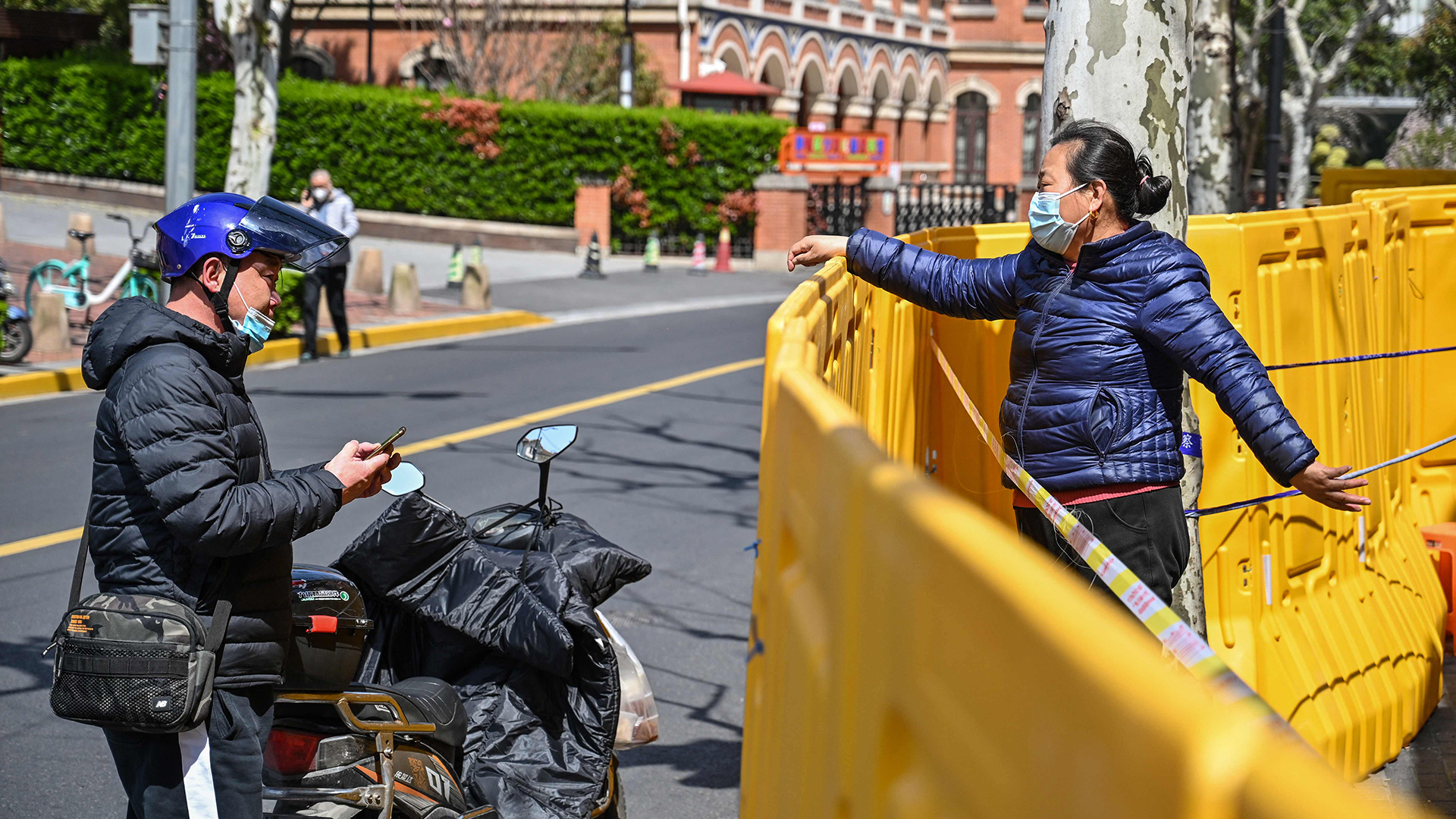 Menschen sprechen über eine Barriere hinweg in Shanghai | AFP