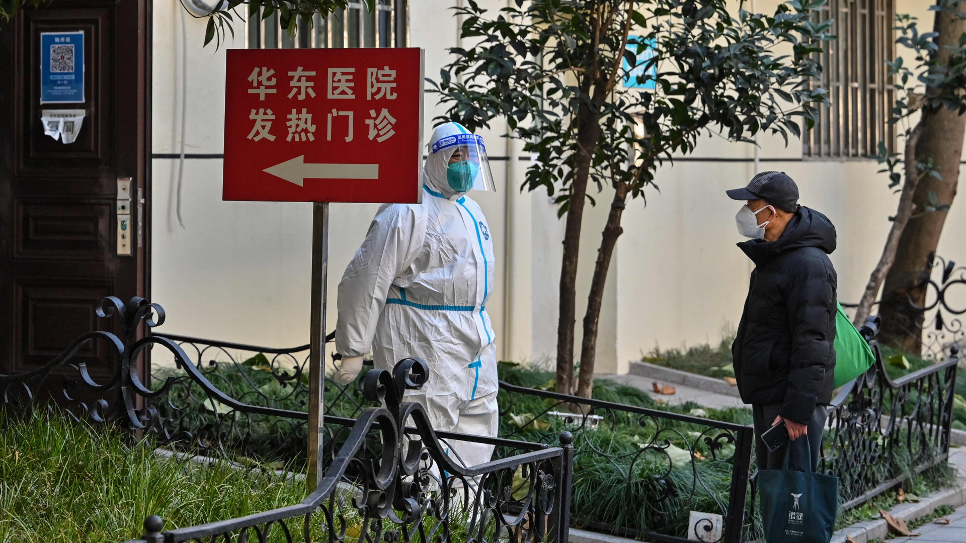 Ein Krankenhausmitarbeiter in Schutzausrüstung steht vor eine Fieberklinik in Shanghai. | AFP