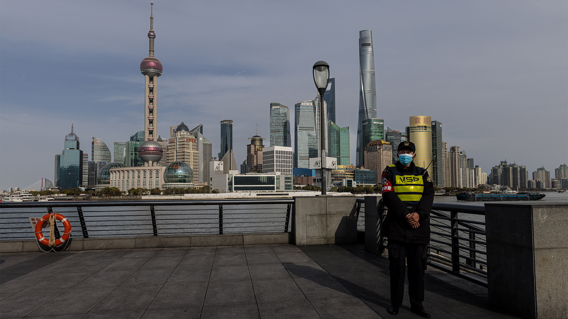 Ein Polizist steht während des Lockwons Wache in Shanghai, im Hintergrund sieht man das Bankenviertel. | EPA