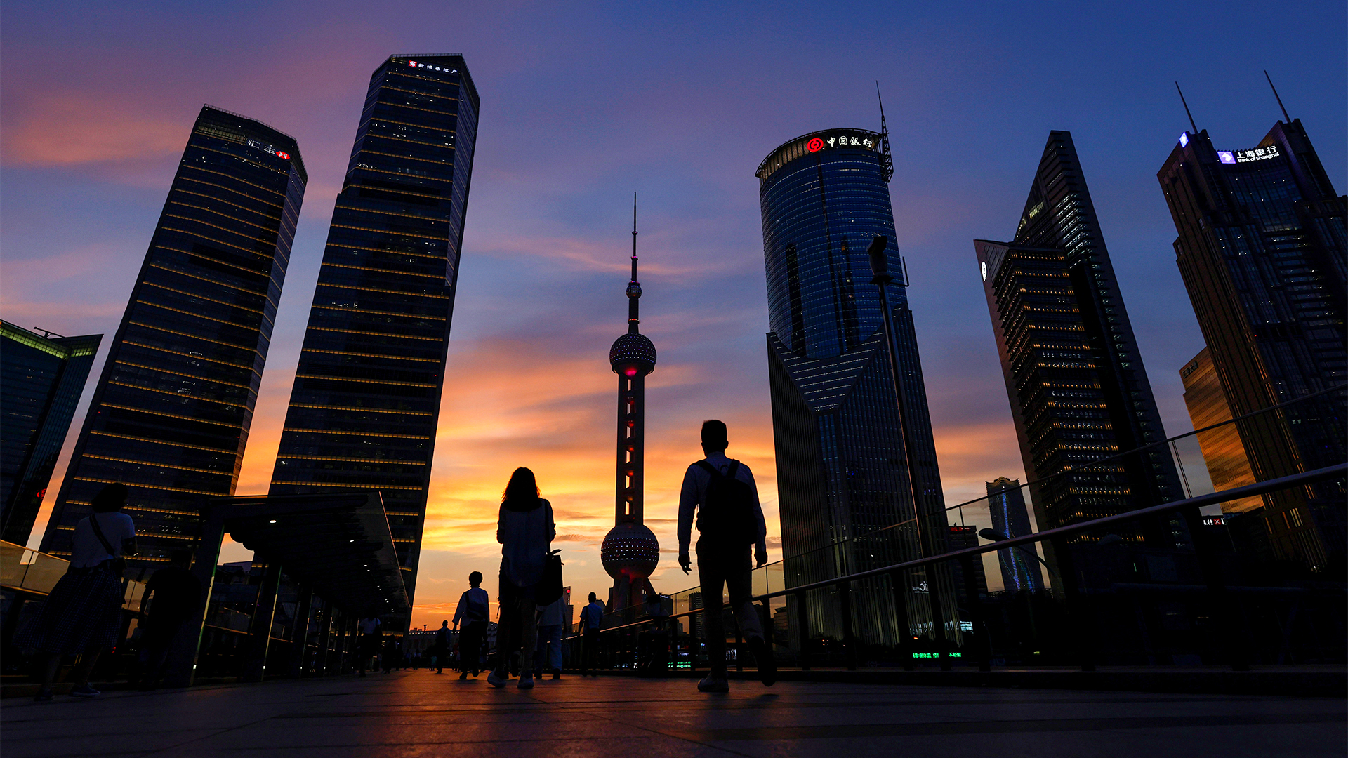 Menschen während des Sonnenuntergangs im Finanzviertel Lujiazui in Shanghai, China. | REUTERS