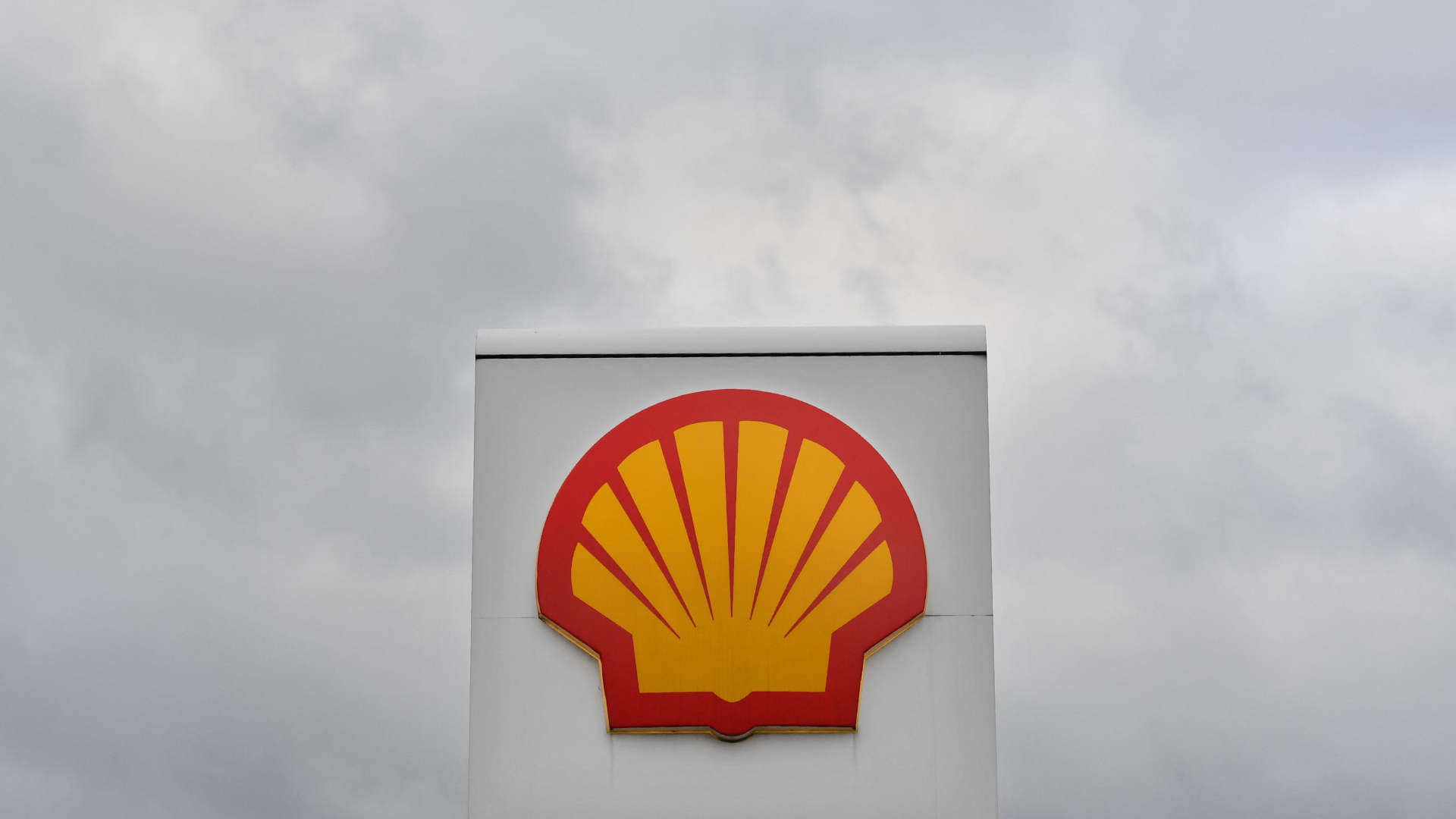 Das Logo des Ölkonzerns Shell vor einem wolkenverhangenen, grauen Himmel.
