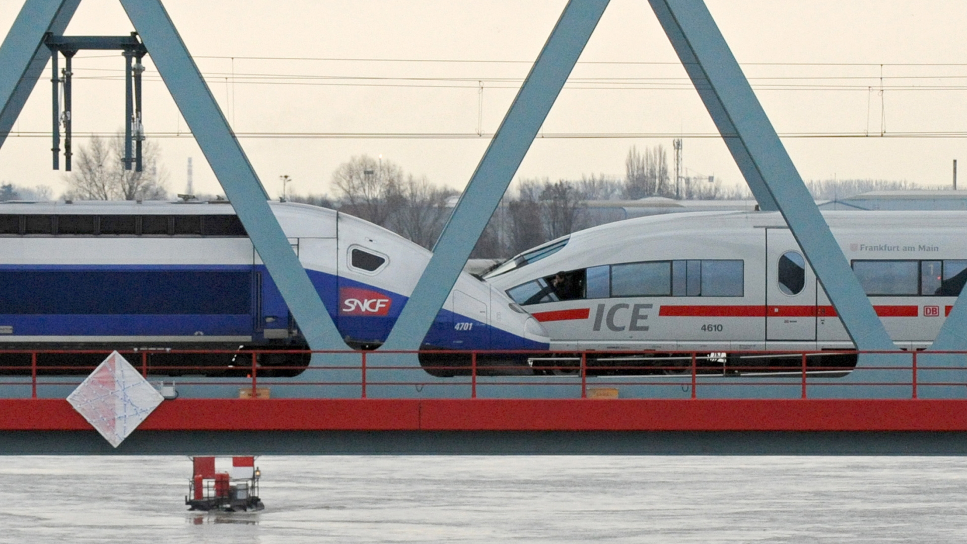 Ein TGV und ein ICE auf einer Rheinbrücke.