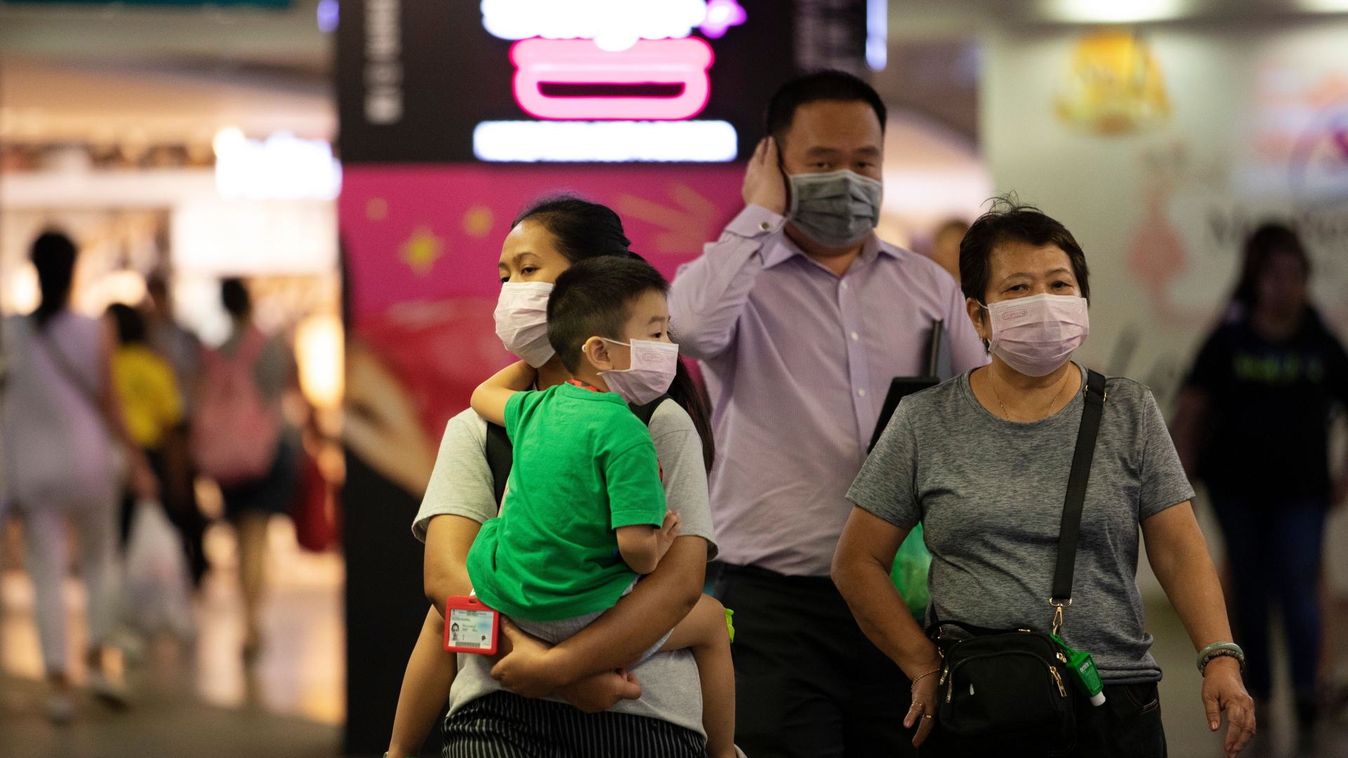 Eine Familie läuft mit Atemschutzmasken vor dem Gesicht durch ein Einkaufszentrum in Singapur. | HOW HWEE YOUNG/EPA-EFE/Shutterst