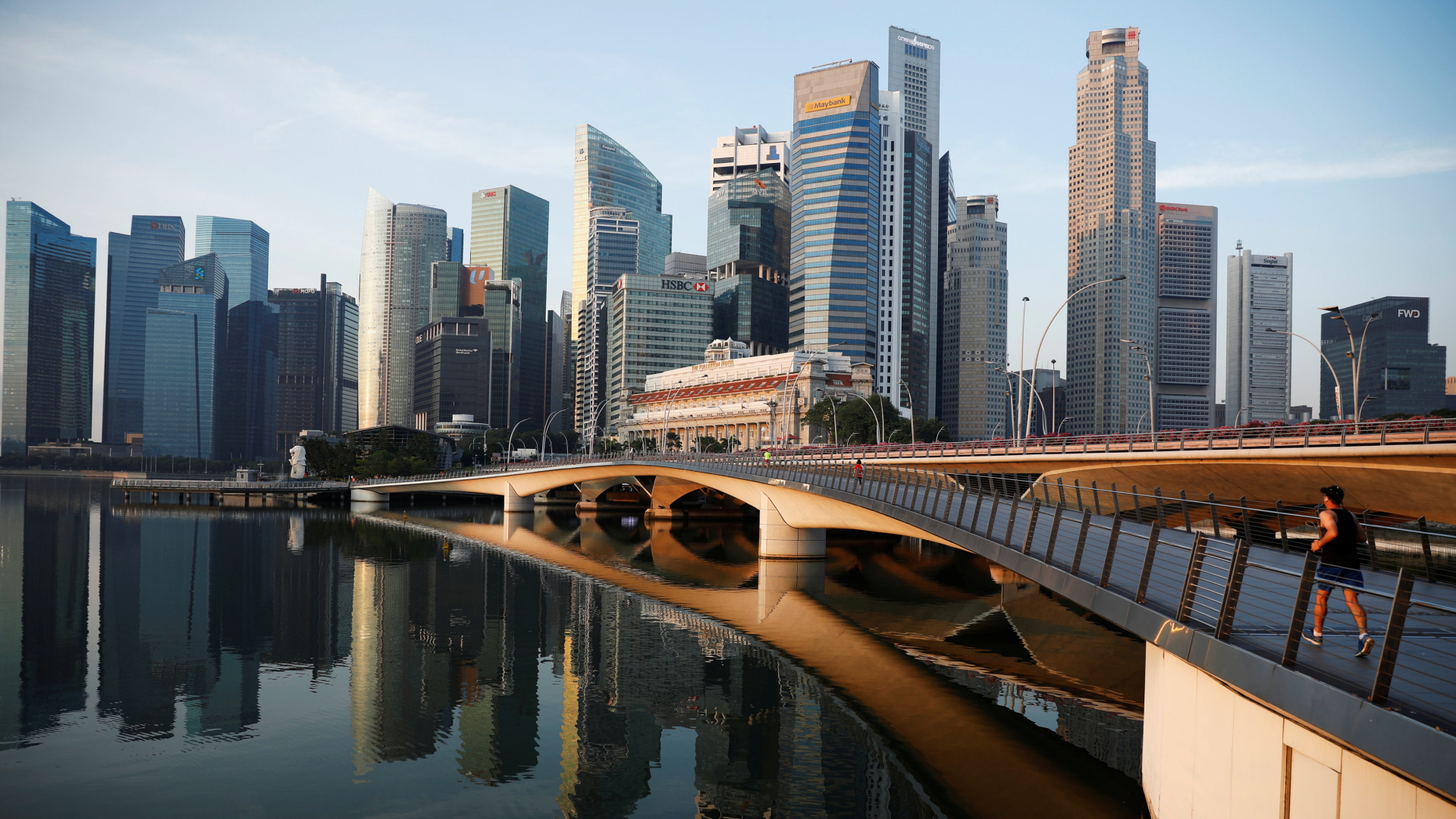 Ein Mann joggt über eine Brücke vor der Skyline von Singapur | REUTERS