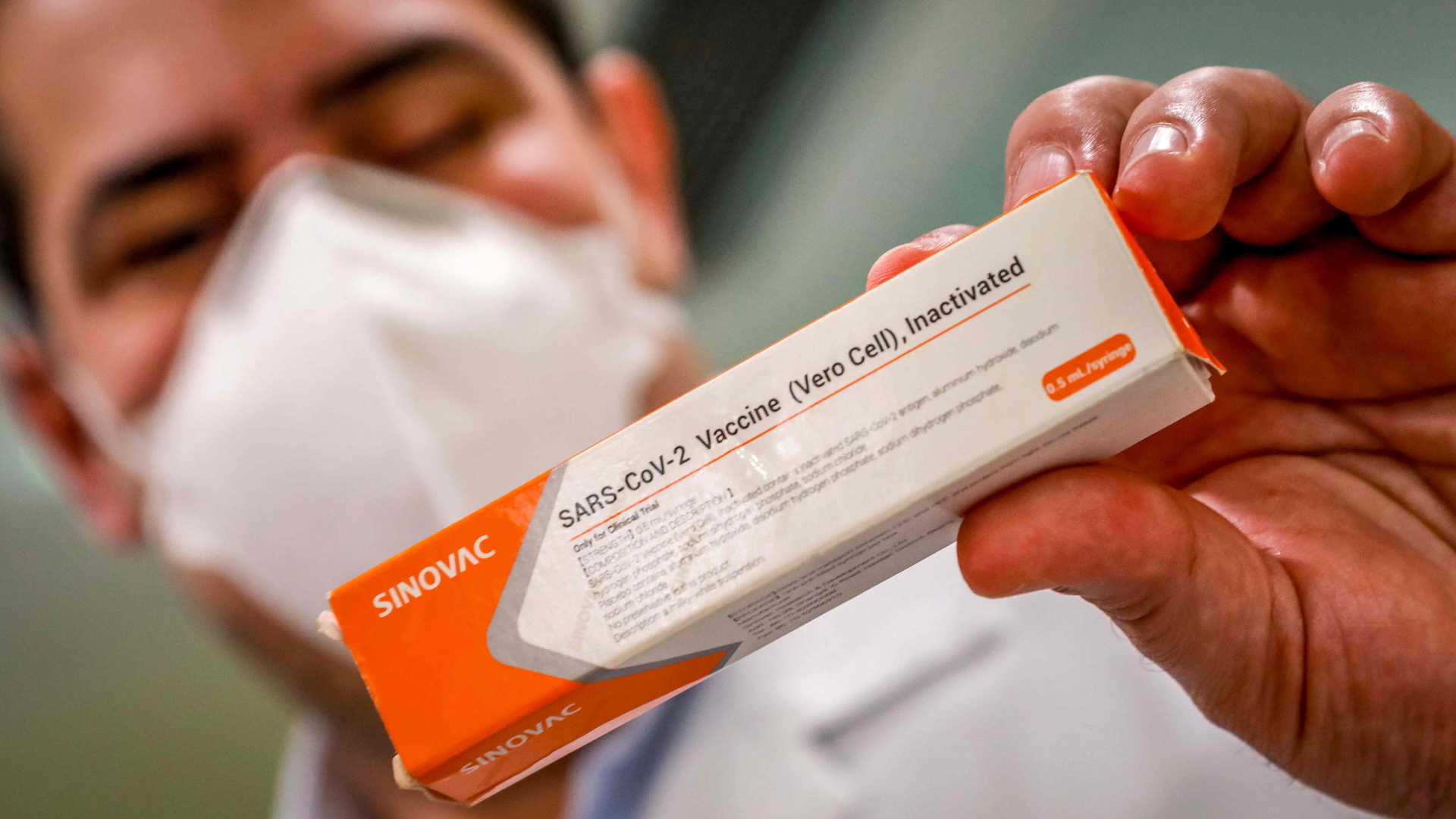 Ein Arzt hält eine Packung des chinesischen Sinovac-Impfstoffes gegen Sars-CoV-2 in der Hand. | Bildquelle: AFP