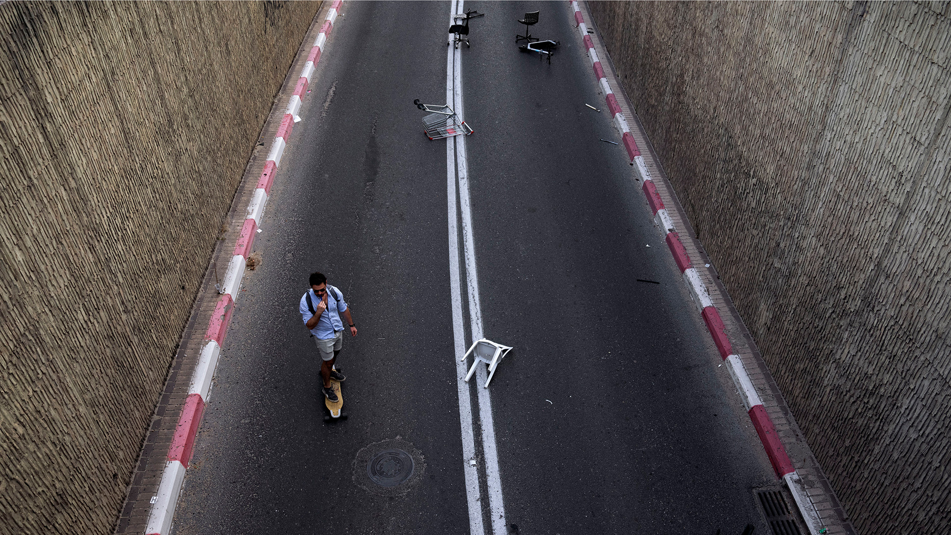 Ein Mann fährt auf seinen Skateboard auf einer autofreien Straße. | AP