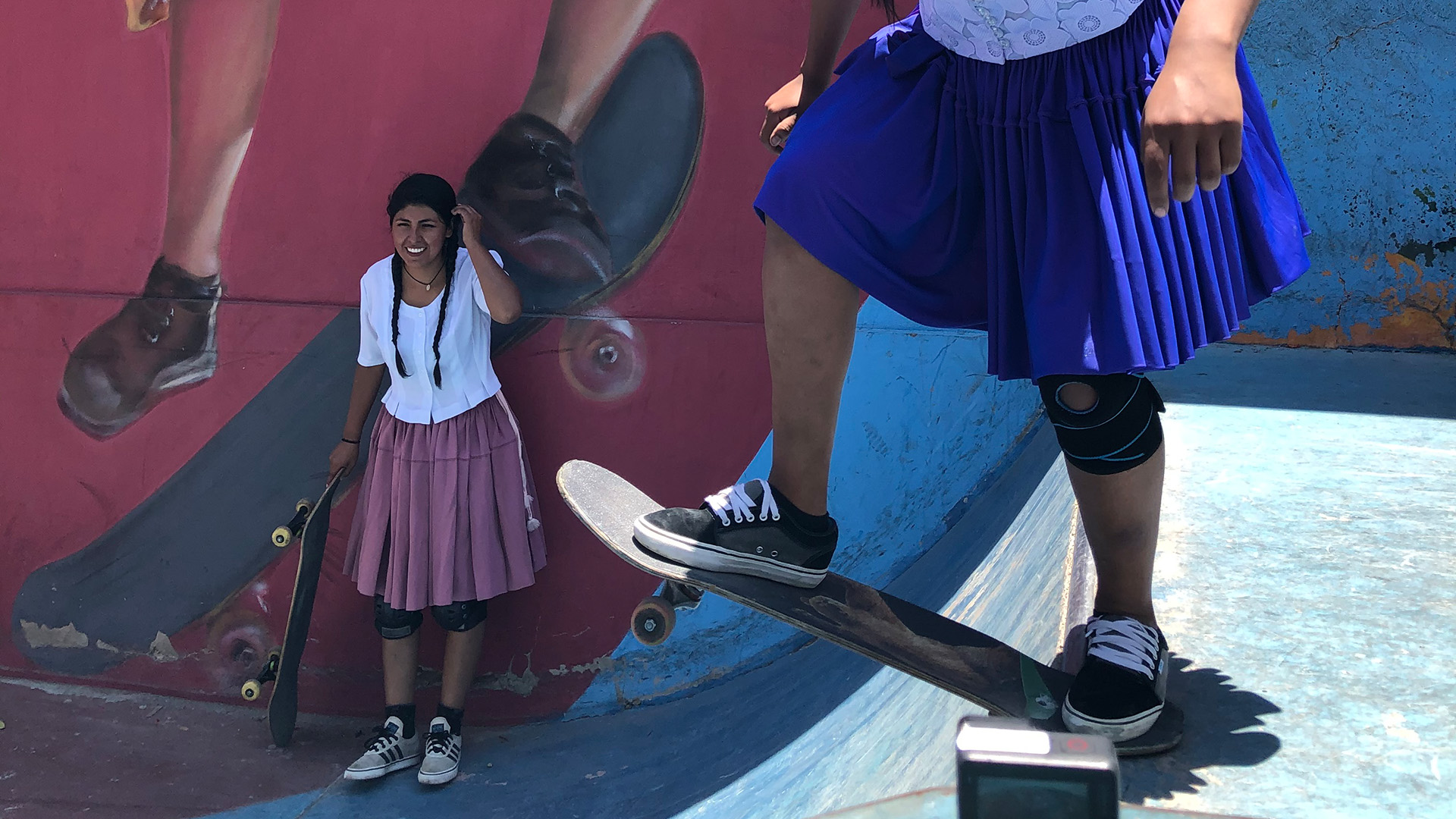 Brenda Mamani Tinta sieht Huara Medina beim Skaten zu. | 