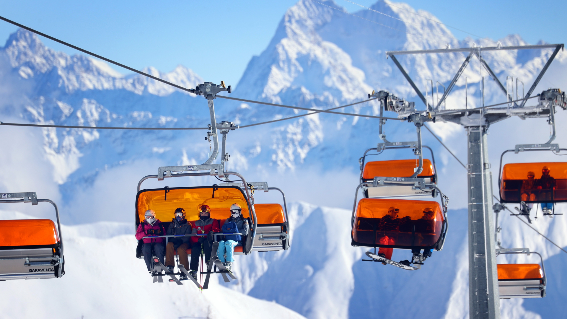 Skifahrer sitzen im Skigebiet Ischgl in einem Sessellift. | dpa