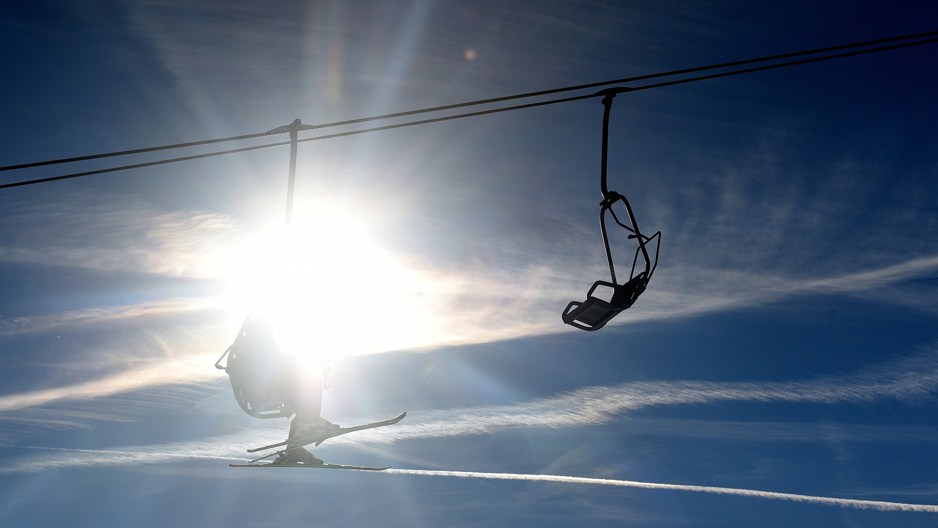 Skifahrer sitzen in Garmisch-Partenkirchen (Bayern) bei Sonnenschein im Lift. | dpa
