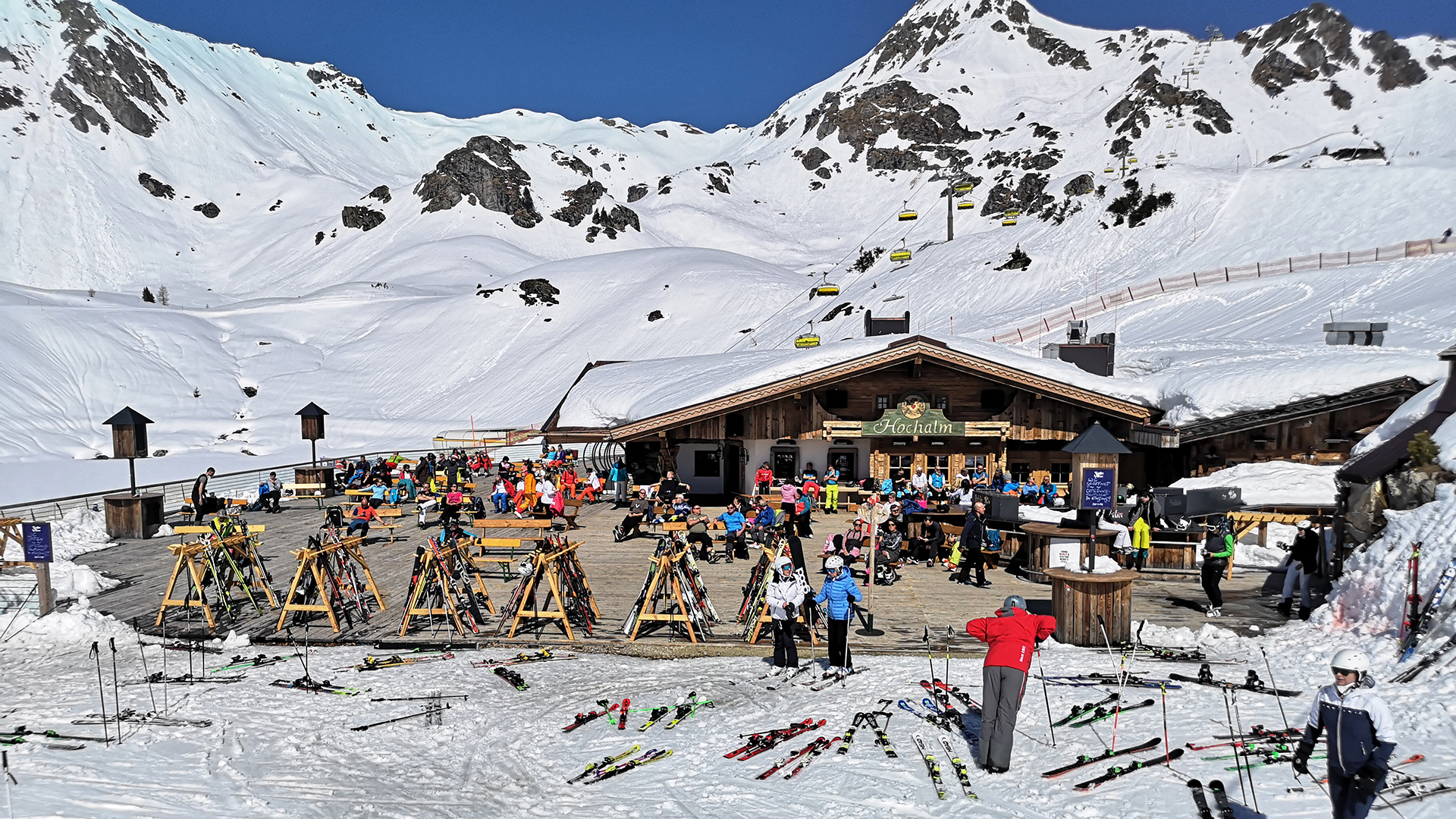 Skifahrer sitzen während einer Pause auf der Terrasse einer geschlossenen Skihütte.