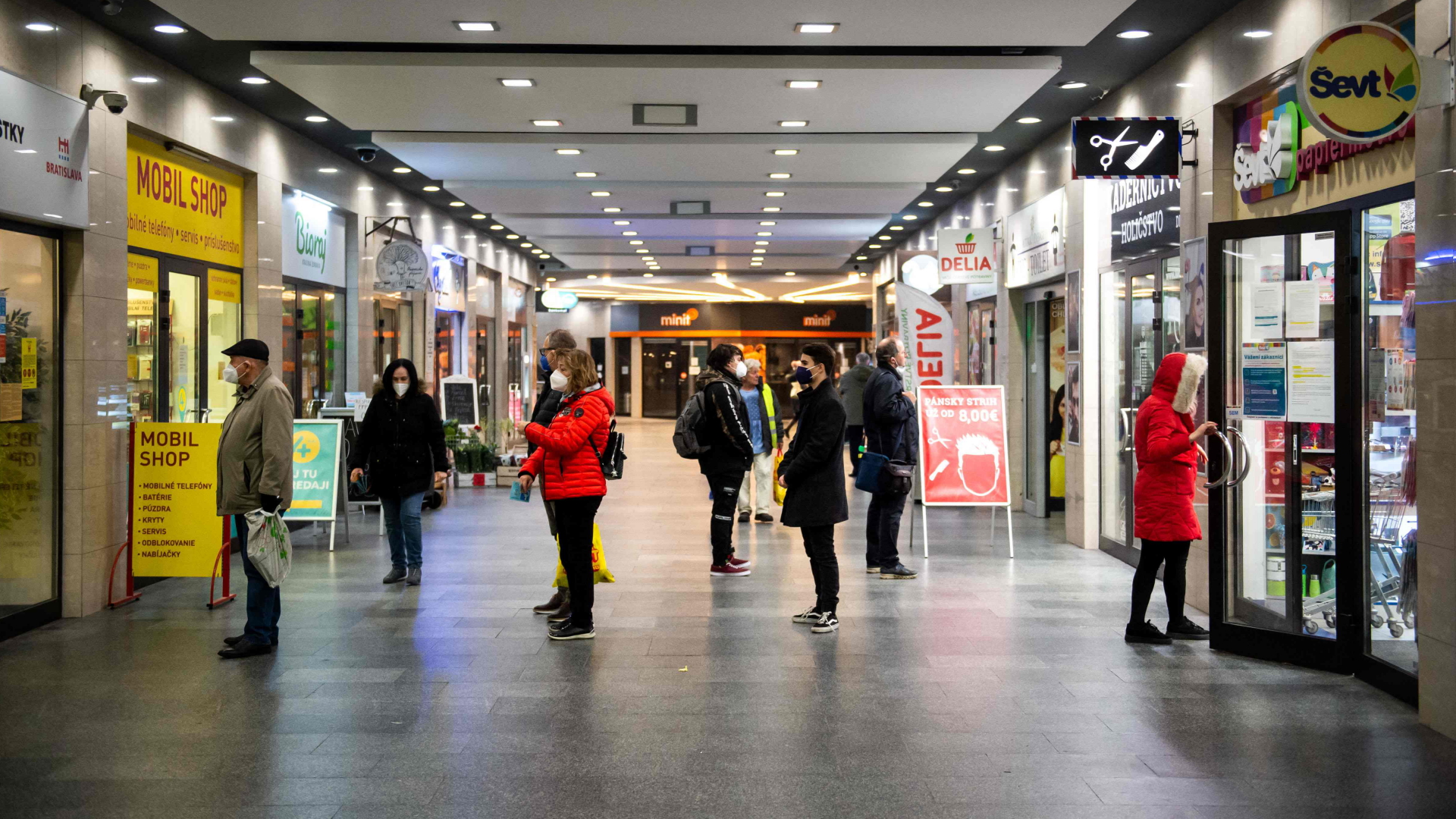 Kunden sind in einem Einkaufszentrum in Bratislava mit Corona-Schutzmasken unterwegs. | AFP