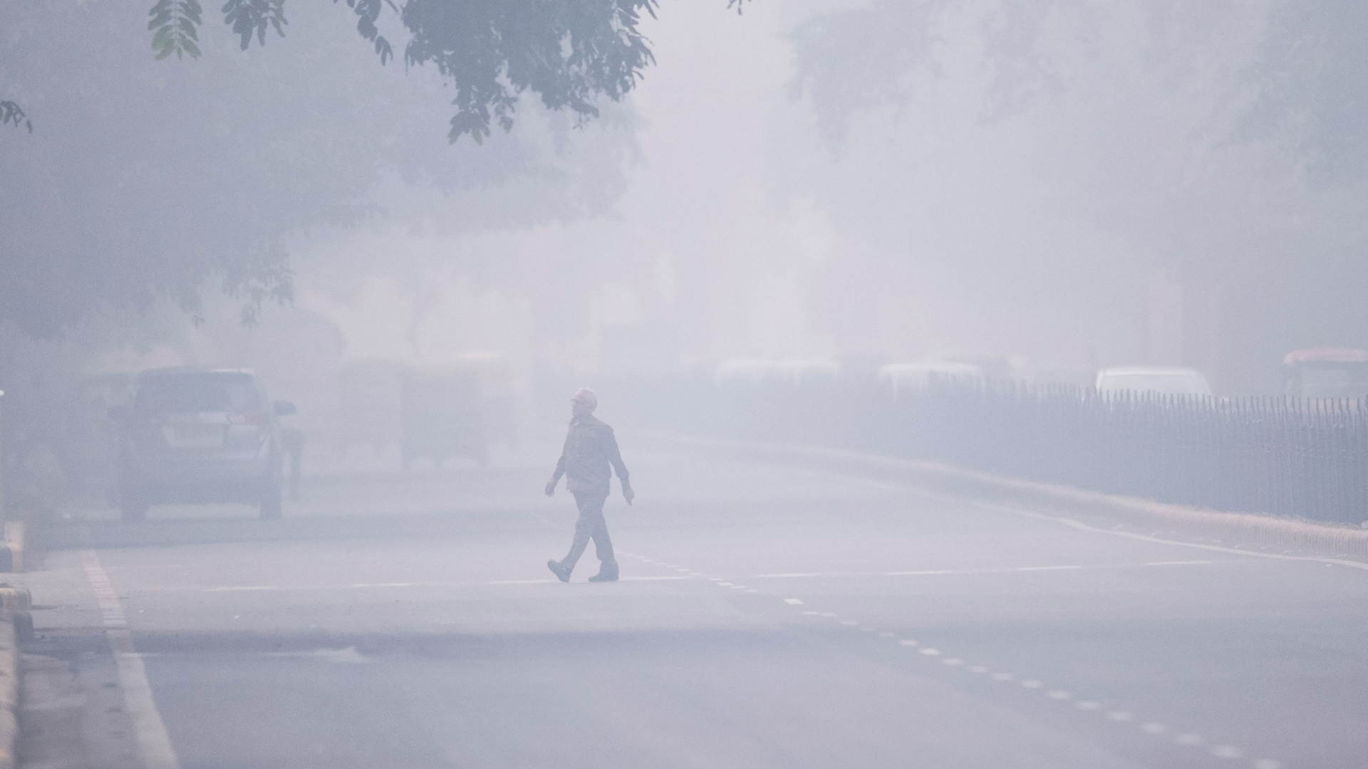 Ein Mann überquert im dichten Smog eine Straße in Neu-Delhi. | AFP