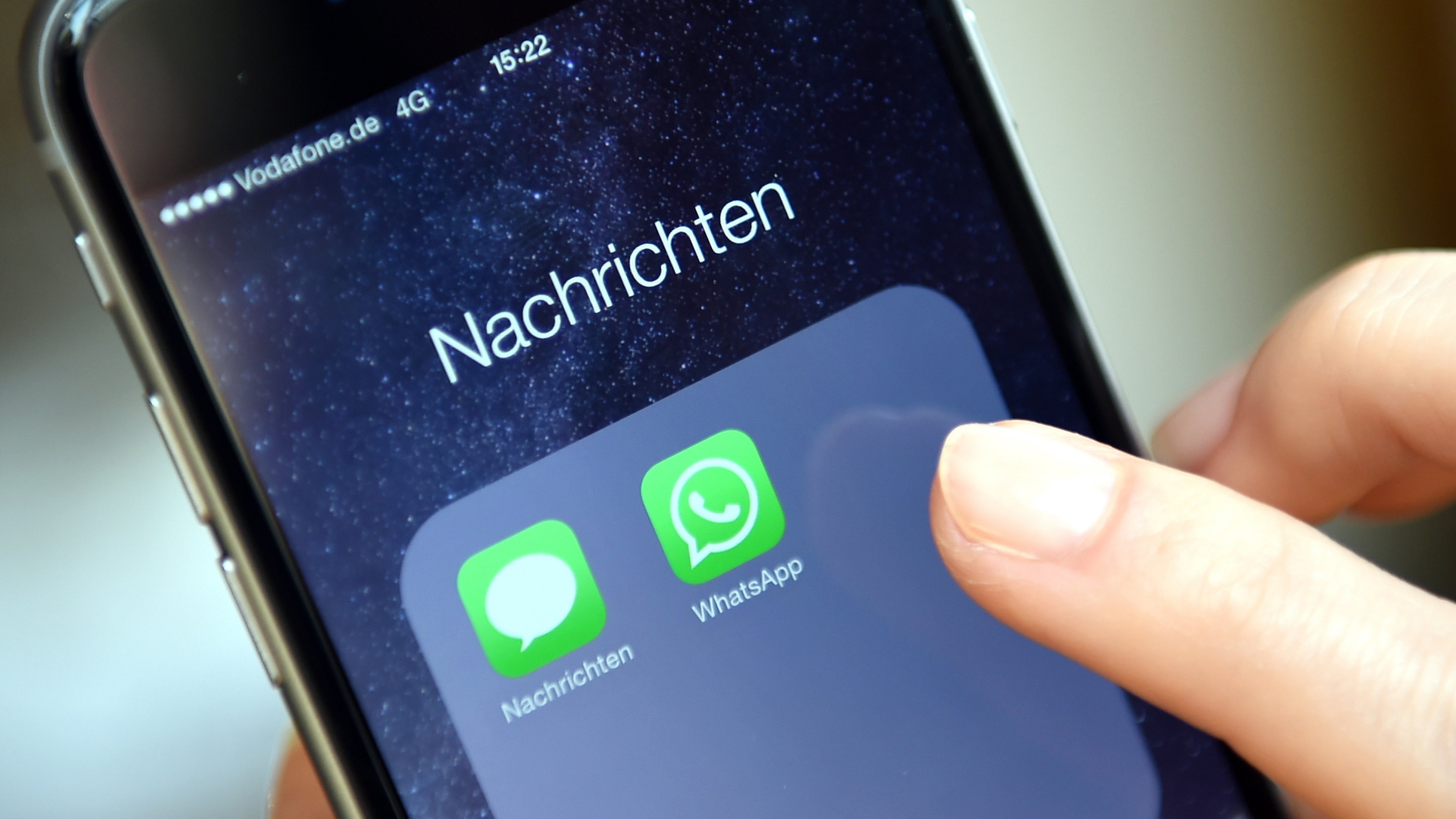 Auf dem Display eines Smartphones werden die Symbole der Apps "WhatsApp" und "Nachrichten" angezeigt