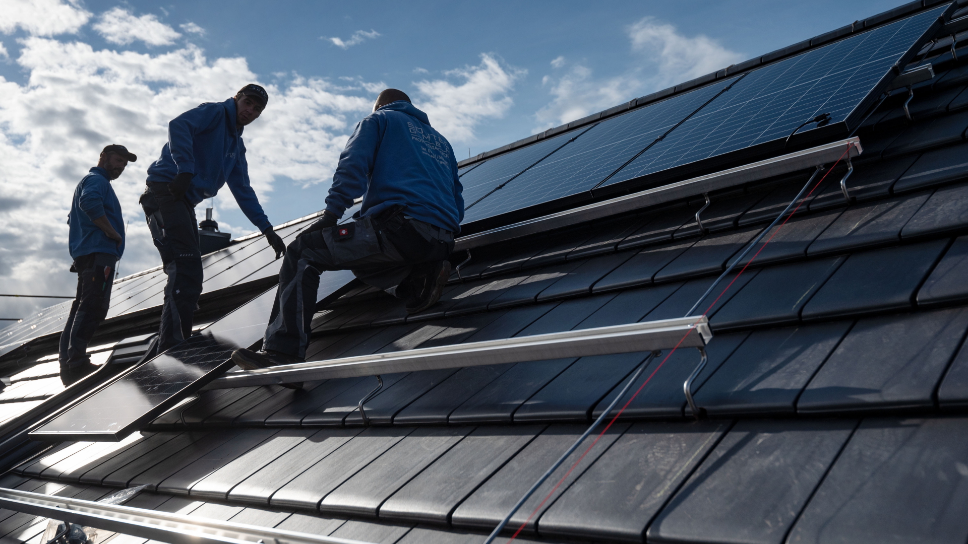 Photovoltaikmodule werden auf dem Dach eines Wohnhauses montiert.