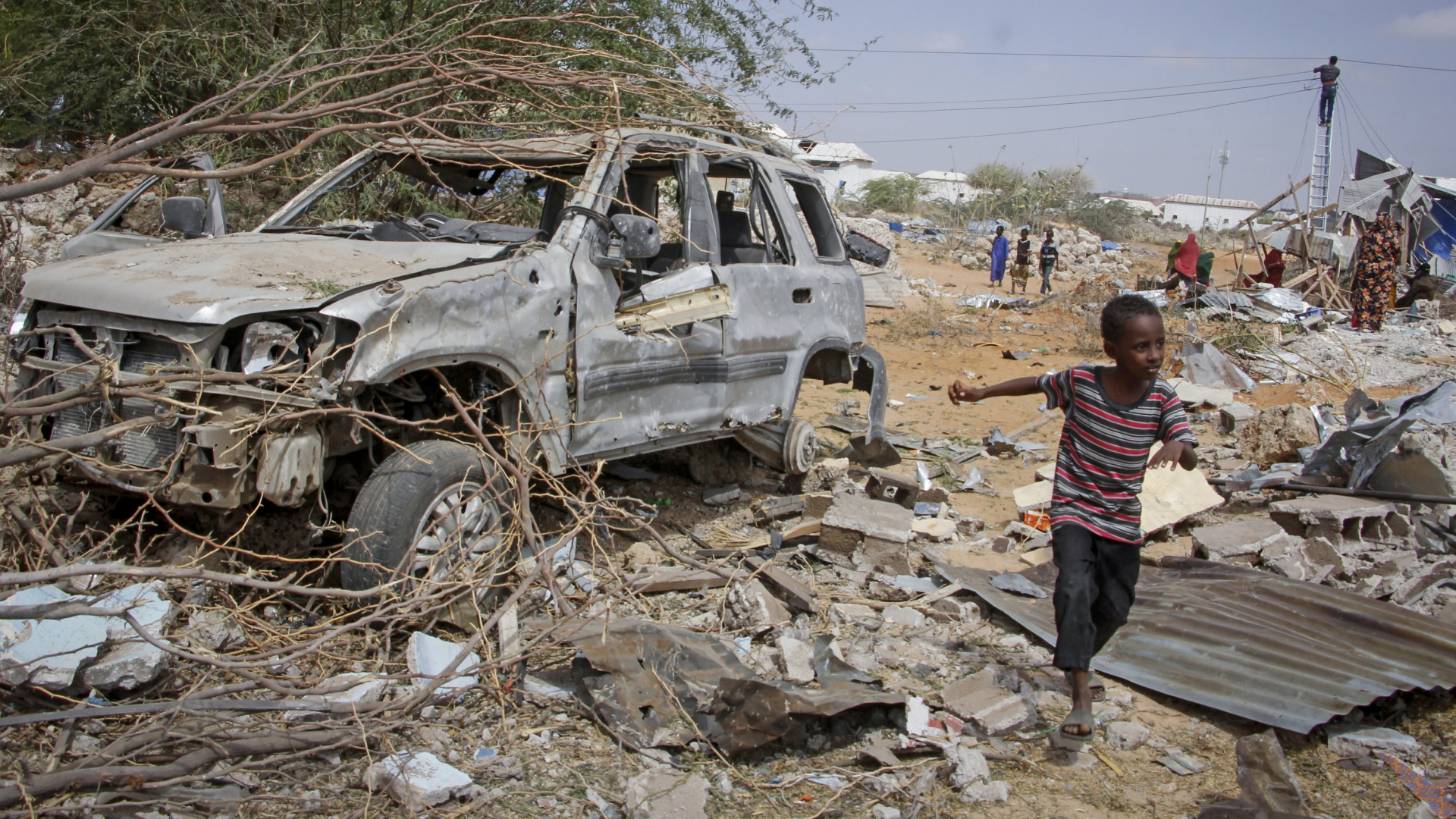 Ein kleiner Junge läuft in der somalischen Hauptstadt Mogadischu am Wrack eines Fahrzeugs vorbei. | AP