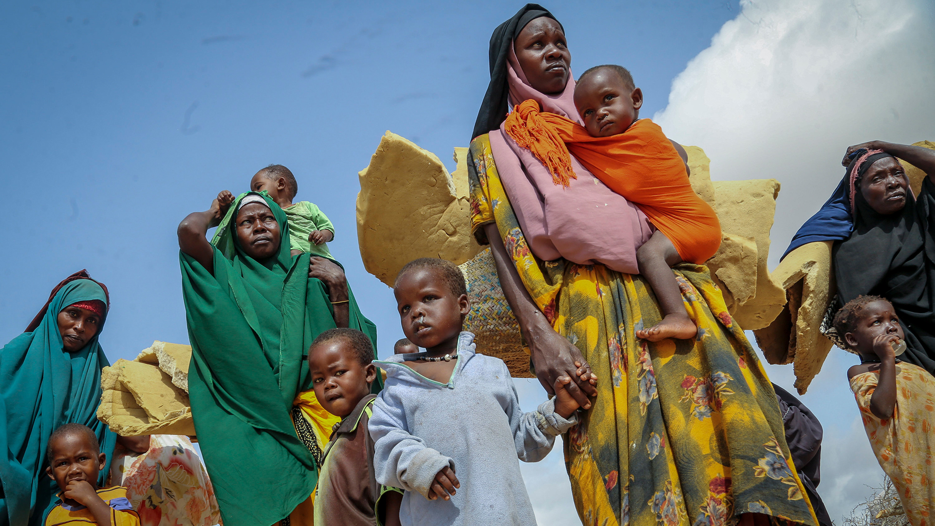 Somalier tragen ihre Habseligkeiten, als sie in einem behelfsmäßigen Lager für Vertriebene am Rande von Mogadischu (Somalia) ankommen. (Archivbild:30. Juni 2022)