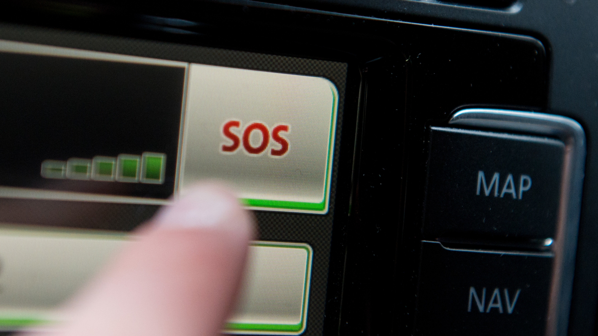Ein Schriftzug "SOS" ist auf dem Display eines Bordcomputers mit Touchpad eines Volkswagen Fahrzeuges zu sehen.