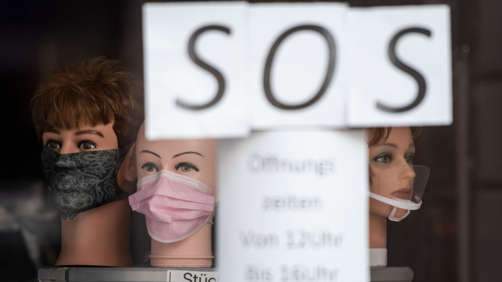SOS ist an dem Schaufenster es Geschäfts in Dortmund zu lesen, in dem Schaufensterpuppen mit Masken stehen. | dpa