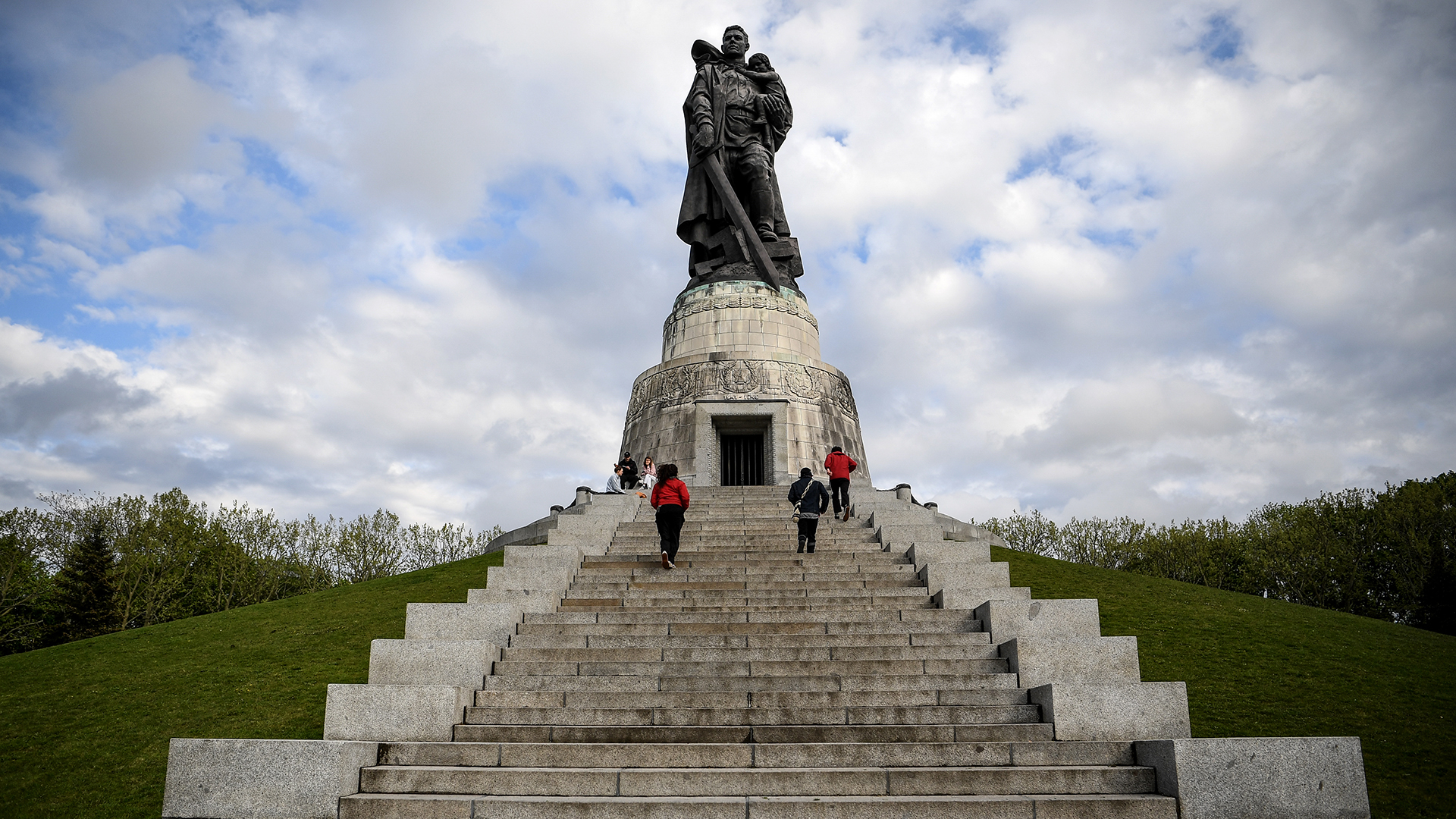 Besucher gehen am Sowjetischen Ehrenmal mit der Skulptur "Der Befreier" im Treptow Park spazieren.  | picture alliance/dpa/dpa-Zentral