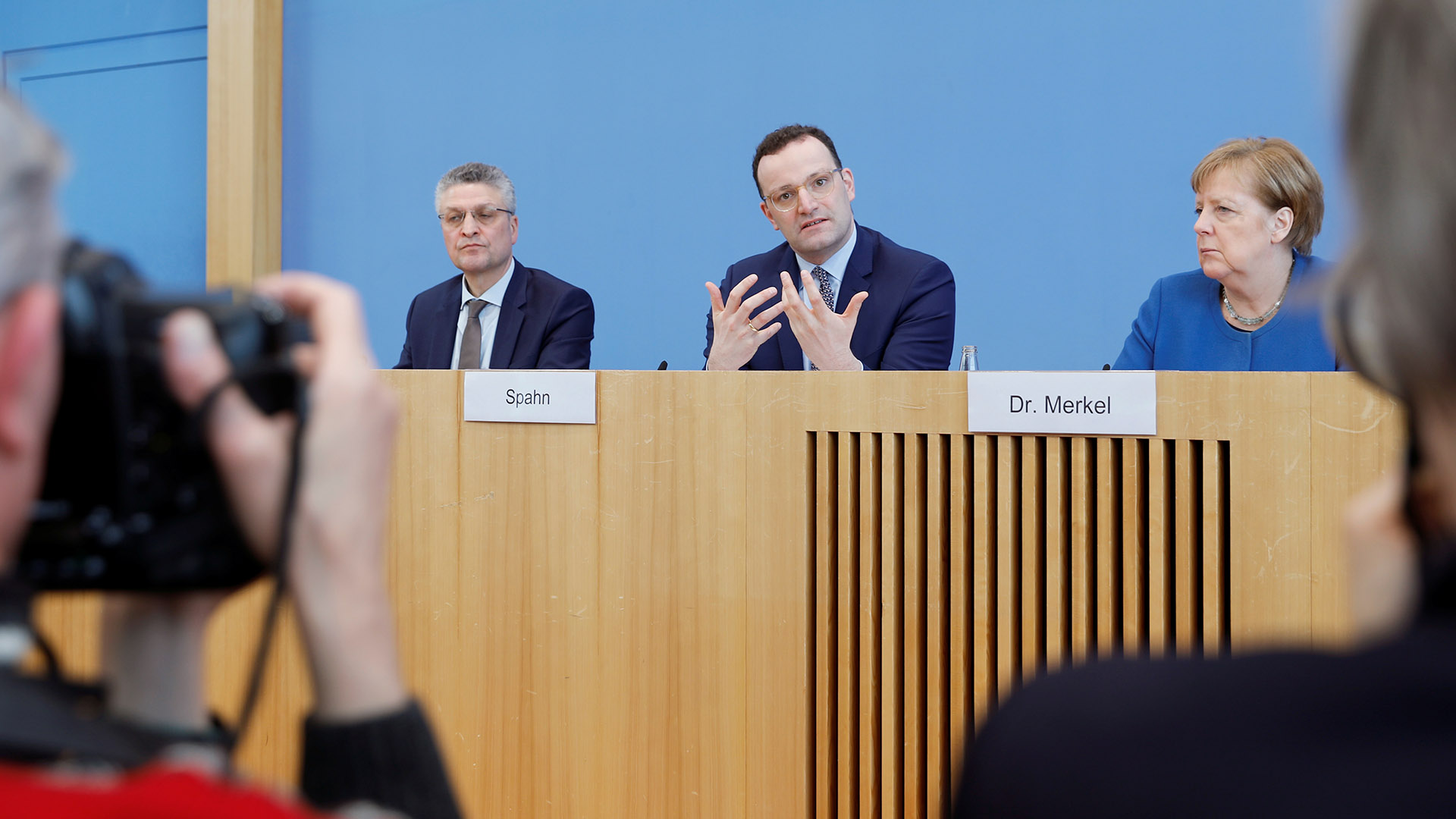 Spahn (Mitte) und Merkel bei einer Pressekonferenz | REUTERS