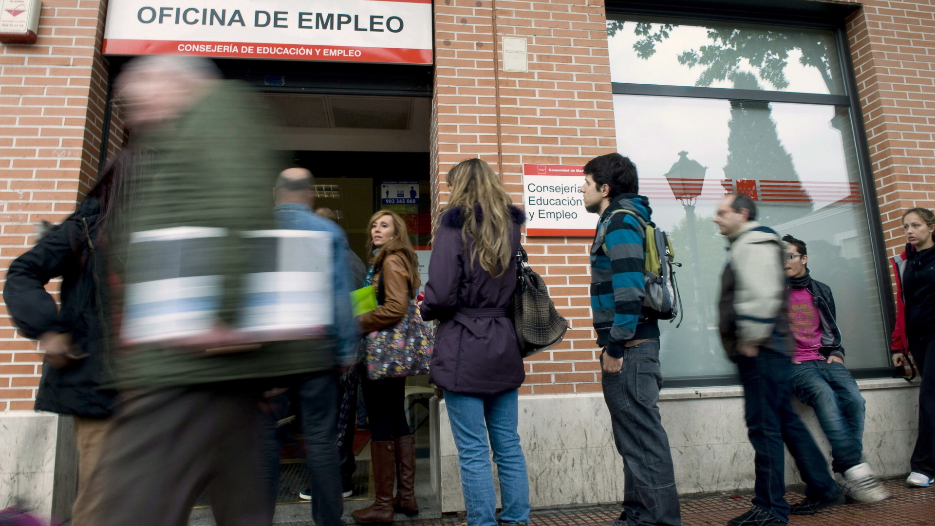 Menschen warten vor einem Arbeitsamt in Spanien. | dpa