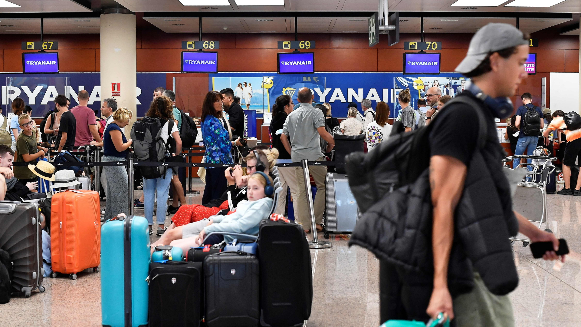 Passagiere stehen am Ryanair-Schalter auf dem Flughafen Barcelona. | AFP