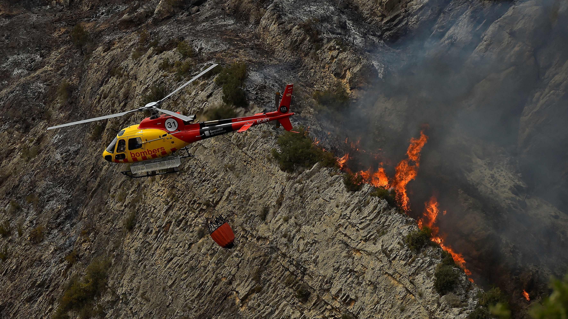 Ein Lösch-Hubschrauber beim Einsatz eines Waldbrandes in Katalonien. | AFP