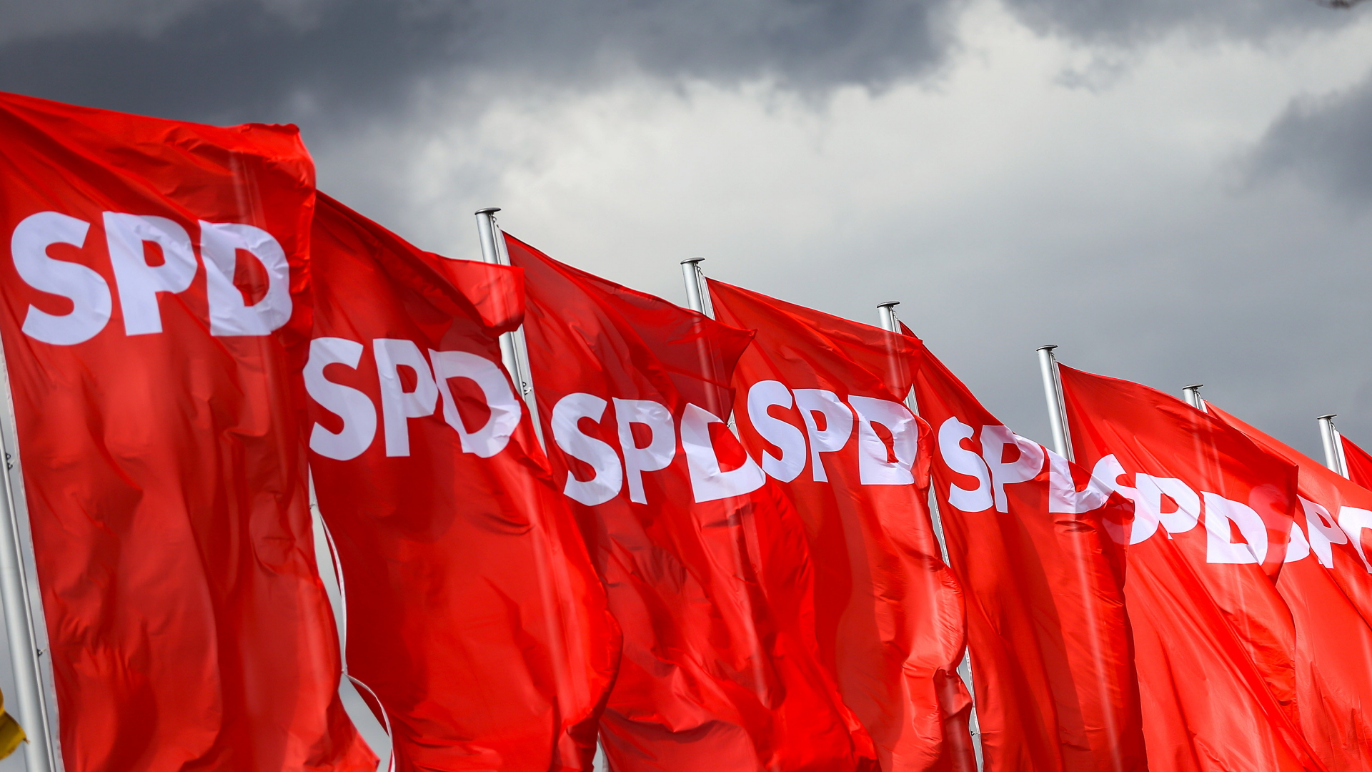 SPD-Fahnen wehen vor dunklen Wolken. | dpa