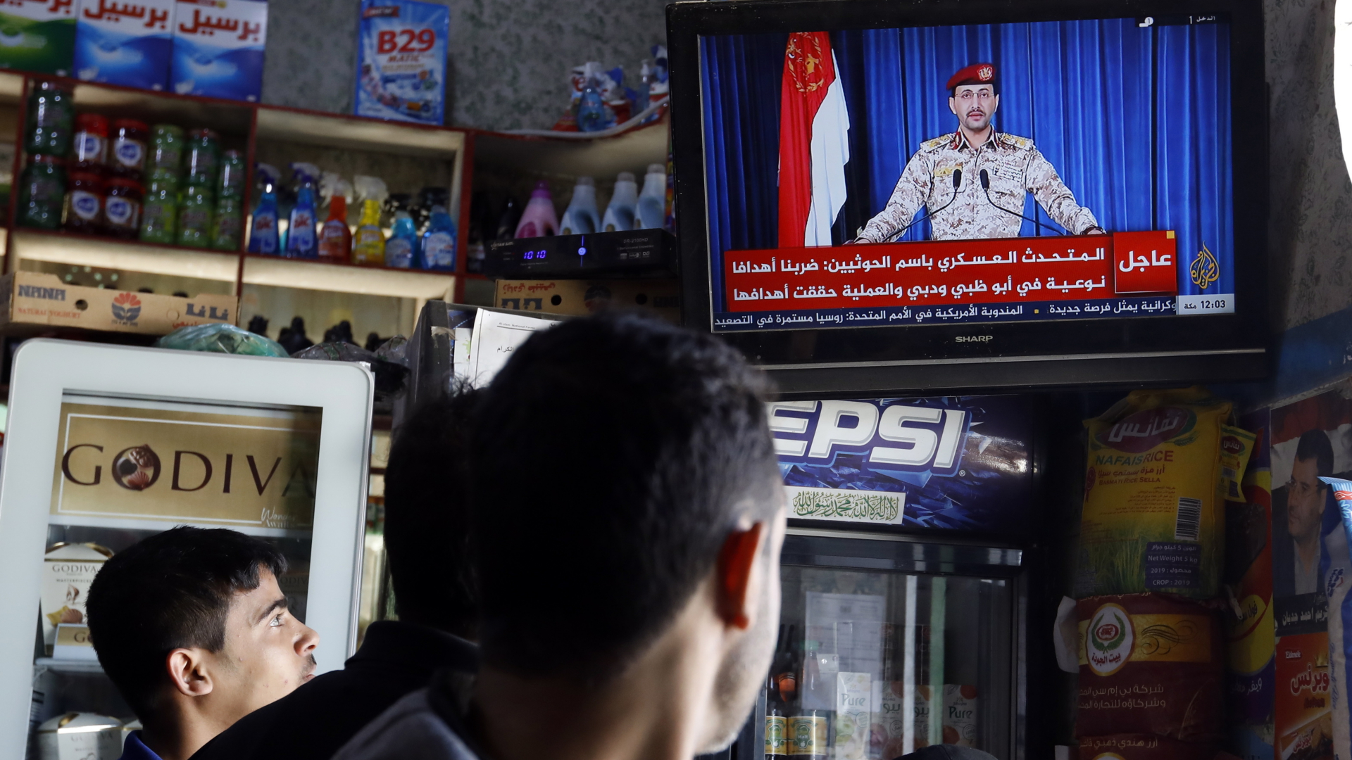 Yemeniten schauen zu einem Fernseher, in dem ein Huthi-Sprecher eine Ansprache hält. | EPA