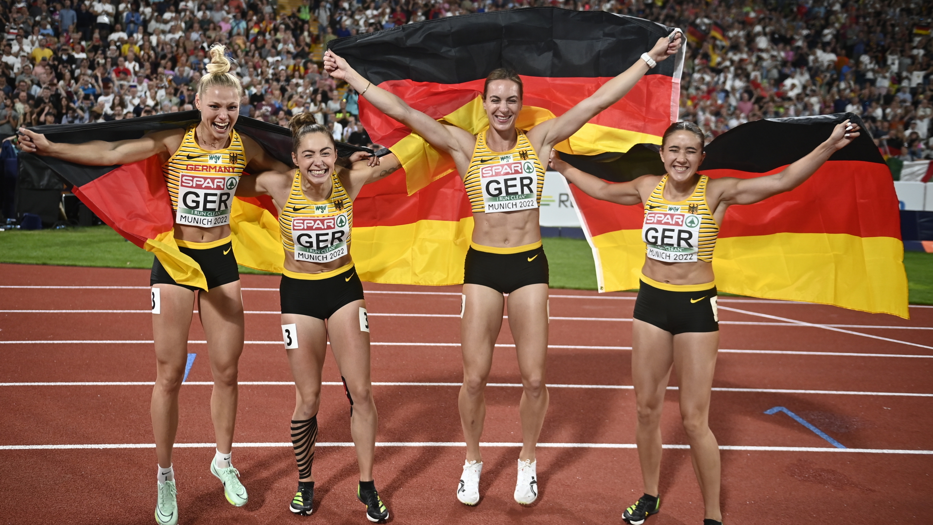 Die Sprinterinnen Alexandra Burghardt, Lisa Mayer, Gina Luckenkemper und Rebekka Haase bejubeln ihren Sieg über 4x100-Meter mit Deutschland-Fahnen. | EPA