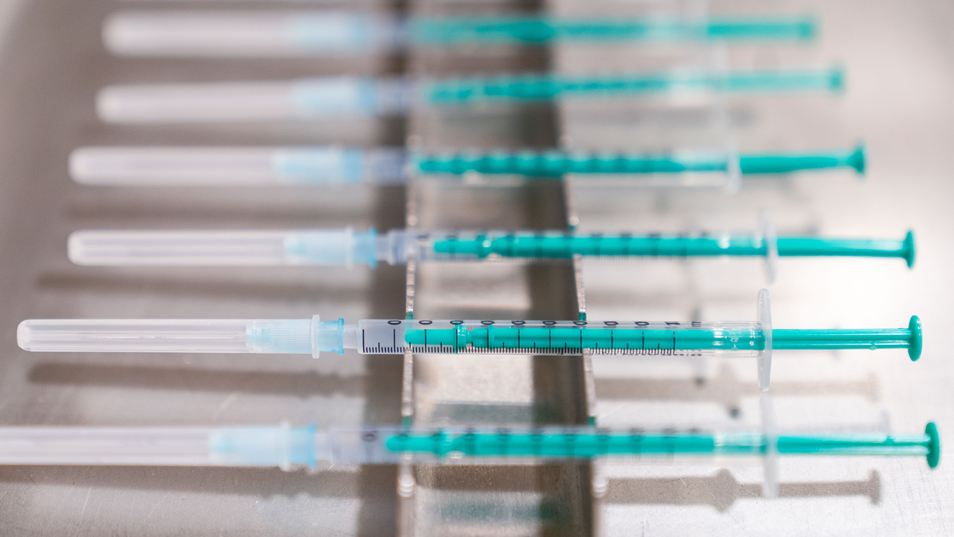Fertig aufgezogene Spritzen mit dem Impfstoff von BioNTech/Pfizer liegen im Impfzentrum Coburg bereit. | dpa