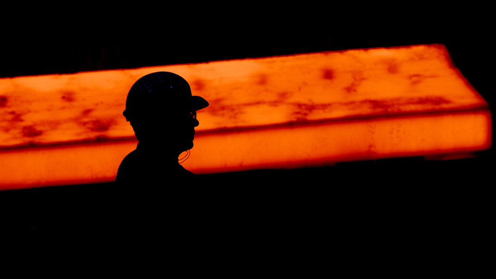 Silhouette eines Stahlarbeiters vor einer glühenden Bramme | null