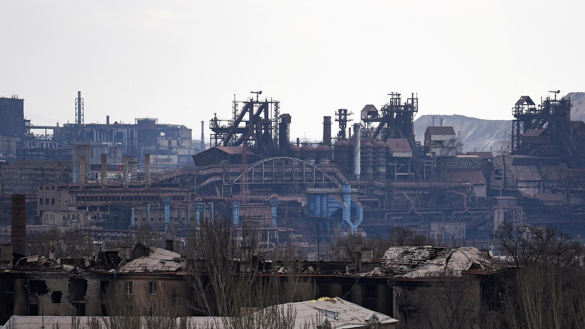 Das Werk des Unternehmens Azovstal hinter Gebäuden, die im Zuge des Ukraine-Russland-Konflikts in Mariupol, Ukraine, beschädigt wurden. | REUTERS