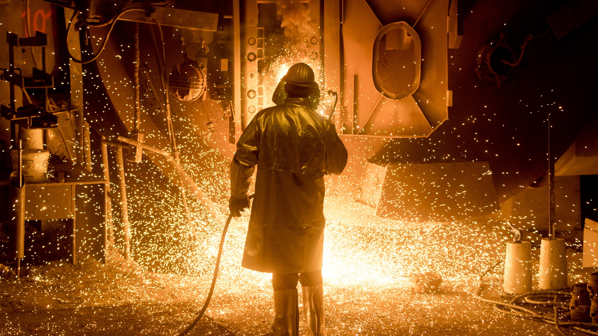 Ein Mitarbeiter in Schutzkleidung bearbeitet auf dem Gelände der Salzgitter AG eine Stahlpfanne.
