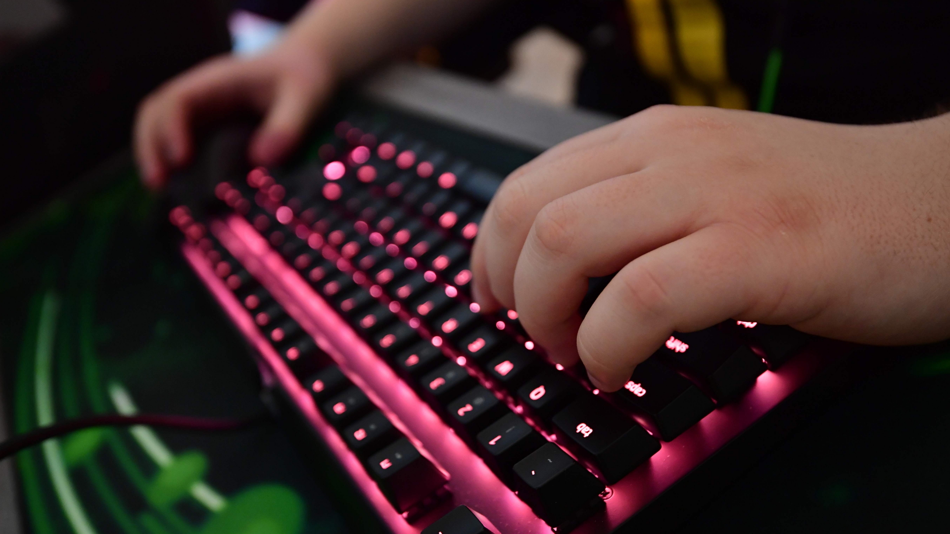 Die Hände eines Gamers auf einer beleuchteten Tastatur