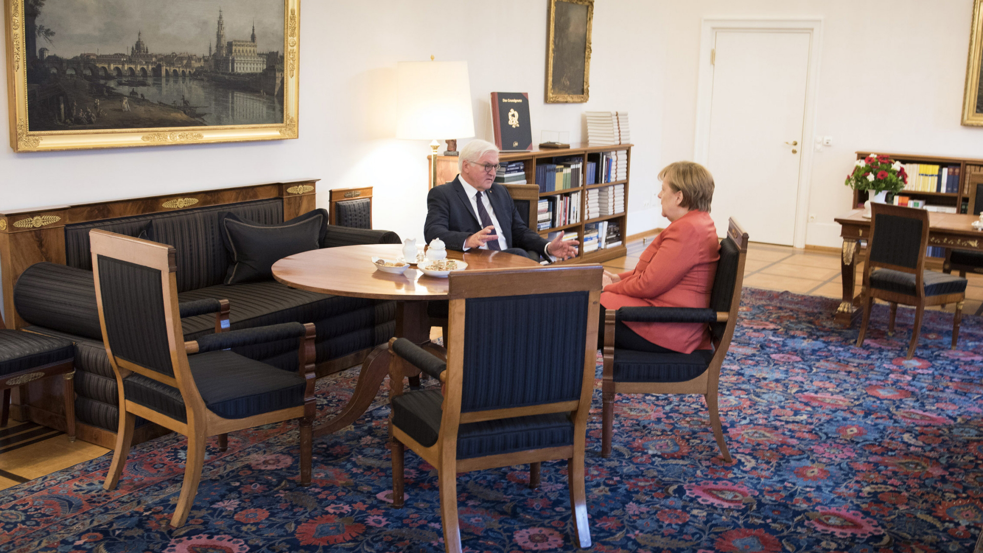 Bundeskanzlerin Angela Merkel und Bundespräsident Frank-Walter Steinmeier unterhalten sich in Schloss Bellevue. | Guido Bergmann/dpa