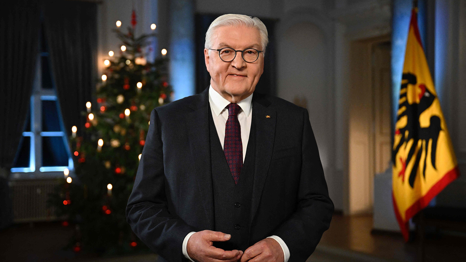 Bundespräsident Frank-Walter Steinmeier steht im Schloss Bellevue, hinter ihm ein geschmückter Weihnachtsbaum. | AFP