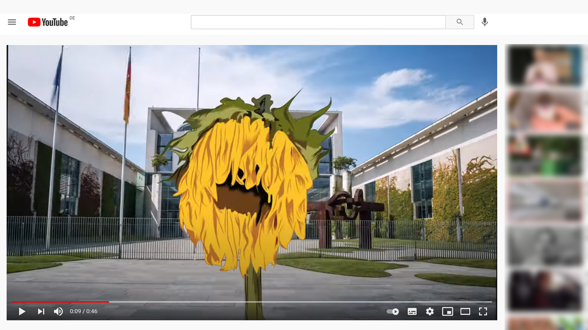Still von einem Youtube-Video, das eine grafische verwelkte Sonnenblume vor dem Kanzleramt zeigt. | youtube