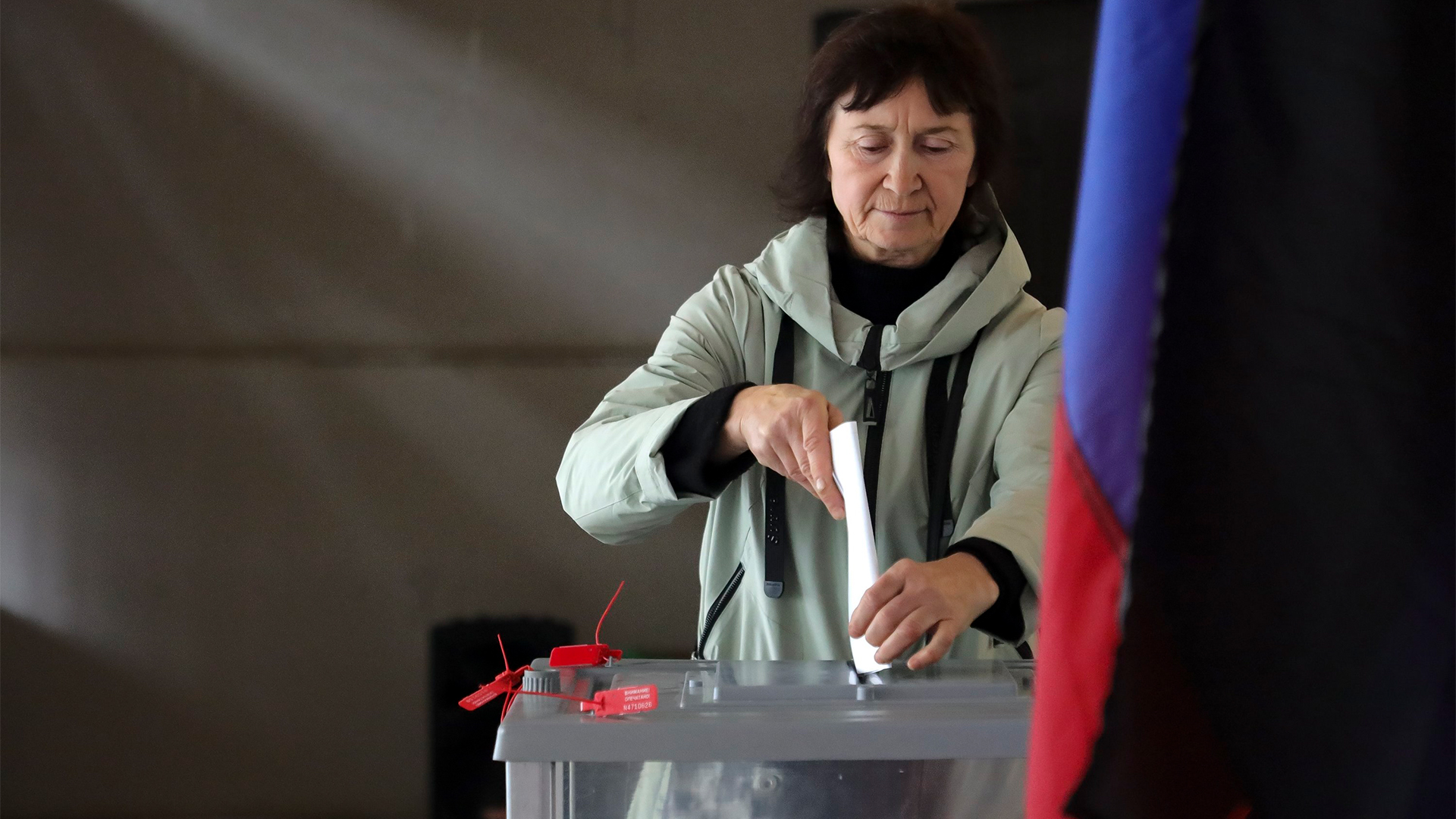 Eine Frau wirft ihren Stimmzettel in eine verschlossene Box.