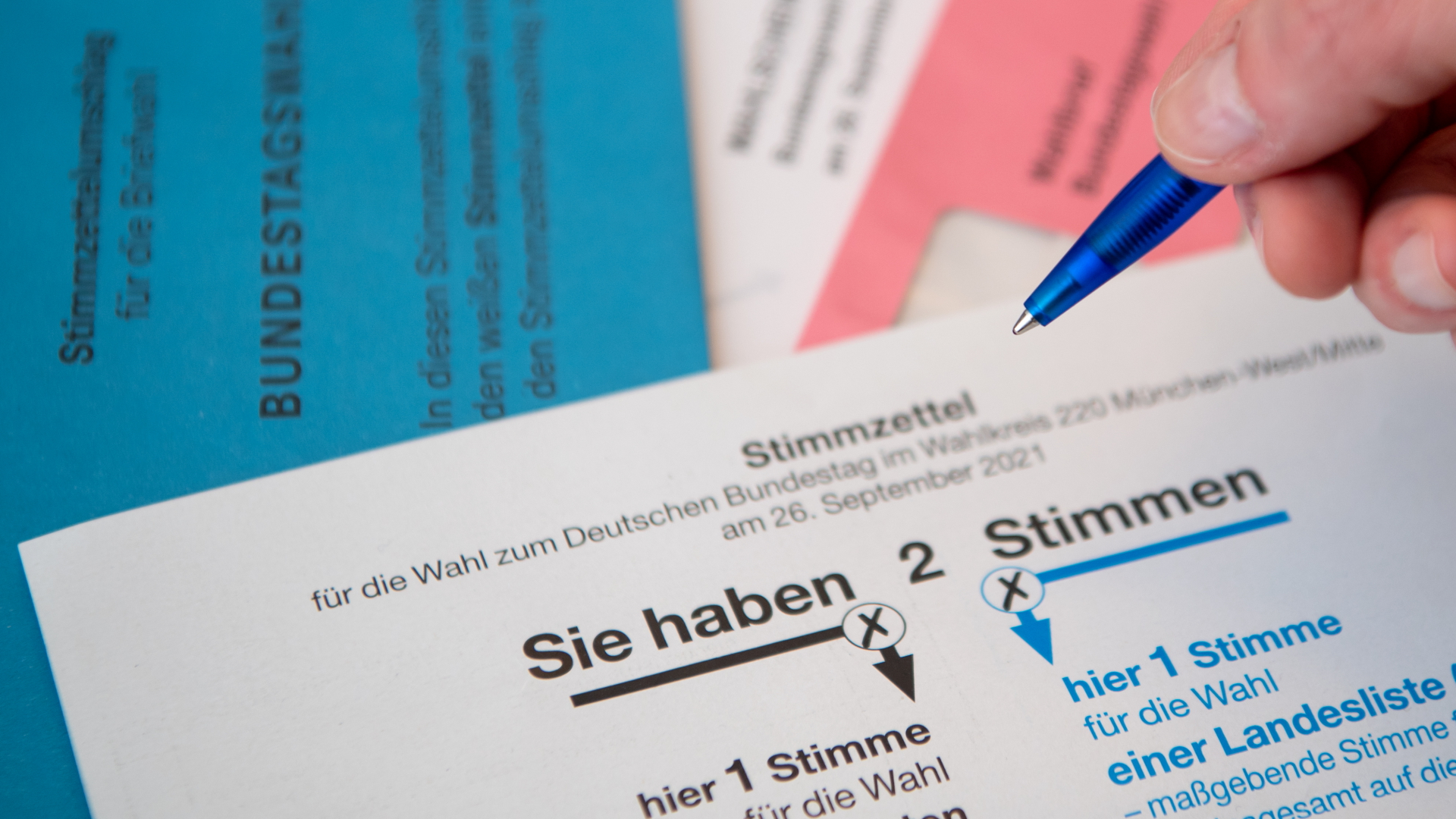 Briefwahlunterlagen für die Bundestagswahl 2021 mit Stimmzettel und Stimmzettelumschlag liegen auf einem Tisch. | dpa