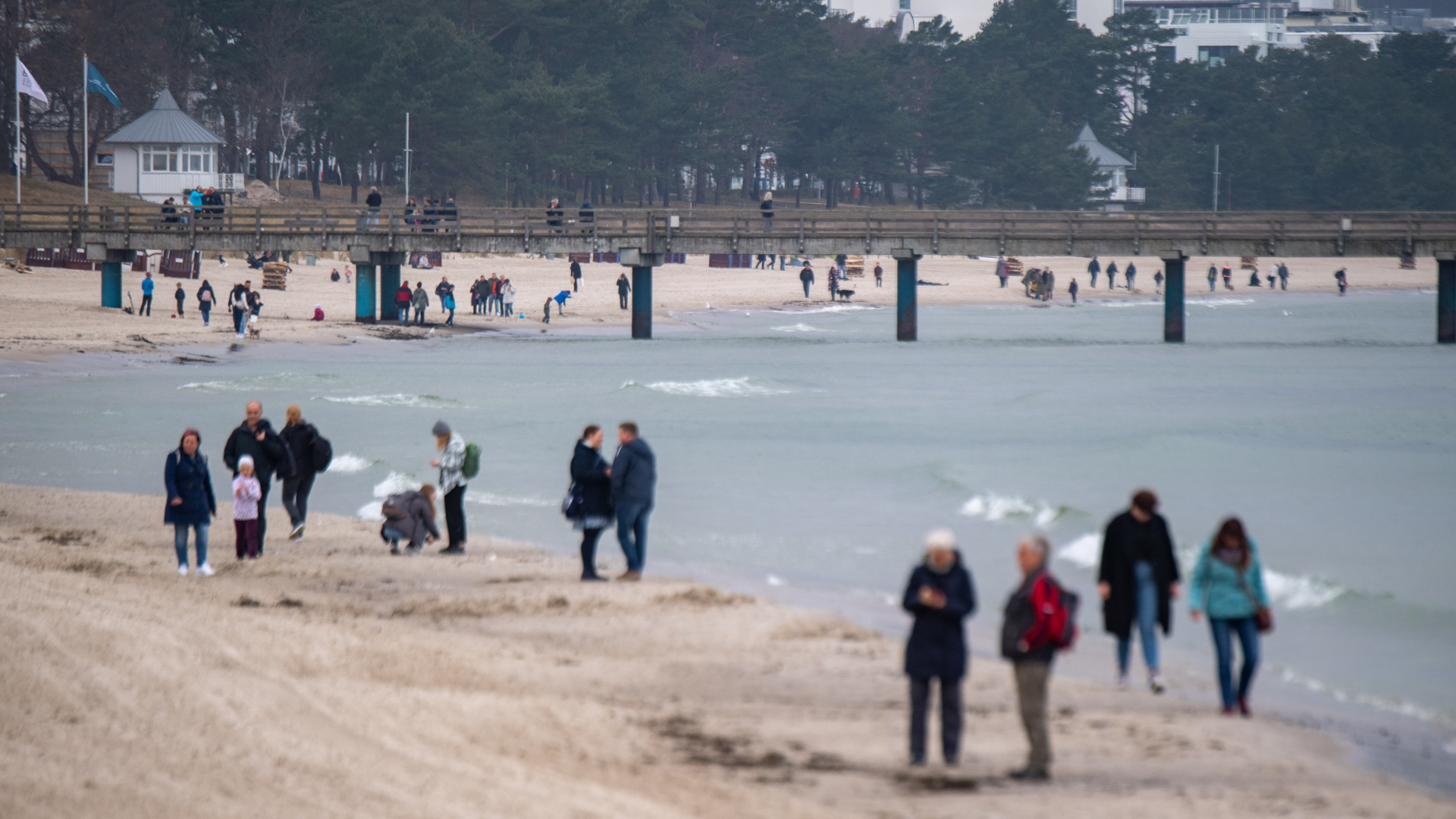 Menschen spazieren am Strand von Binz. | dpa