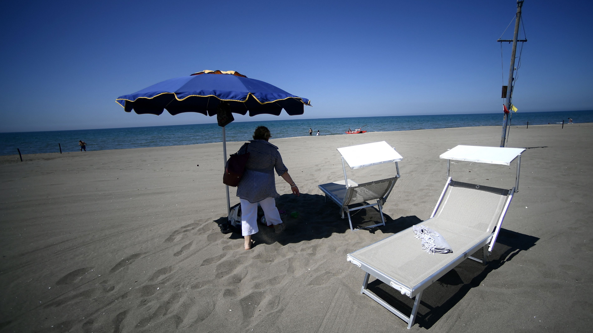 Sonnenschirm und Liegen an einem Strand nahe Rom | AFP