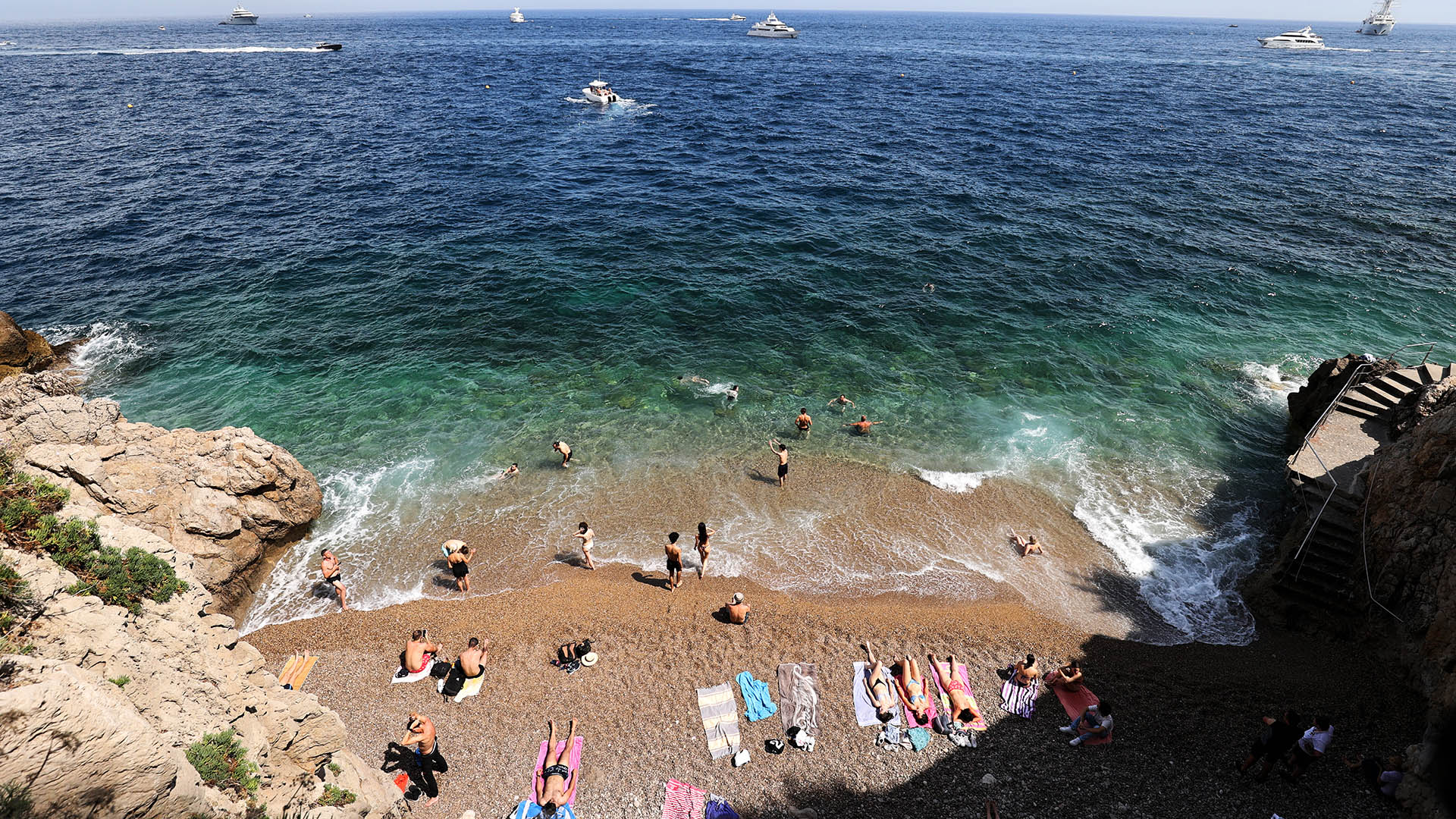 Menschen sonnen sich am Strand von Monte Carlo in Monaco. | picture alliance / empics