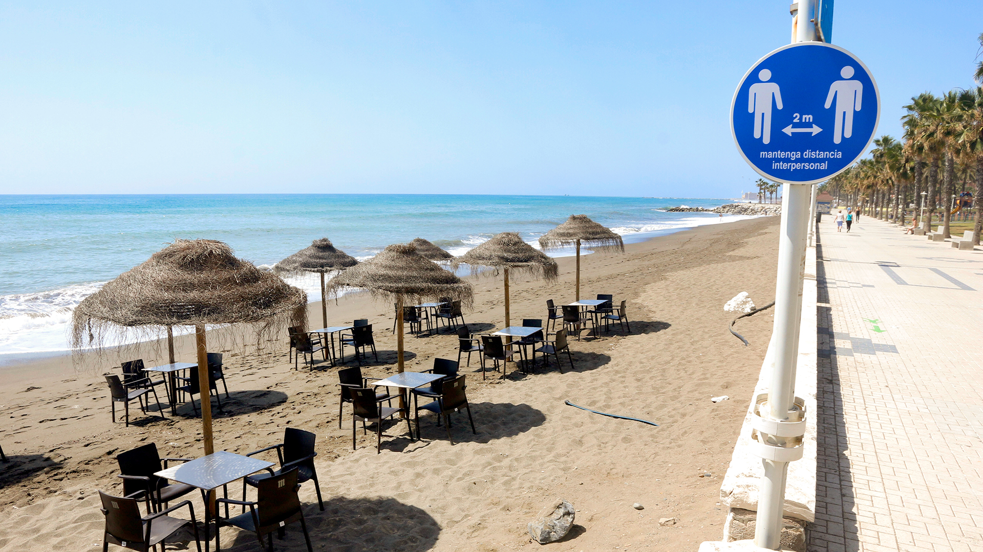 Ein Schild an einem Strand in Malaga, Spanien, empfiehlt zwei Meter Abstand zu anderen Personen zu halten.  | dpa
