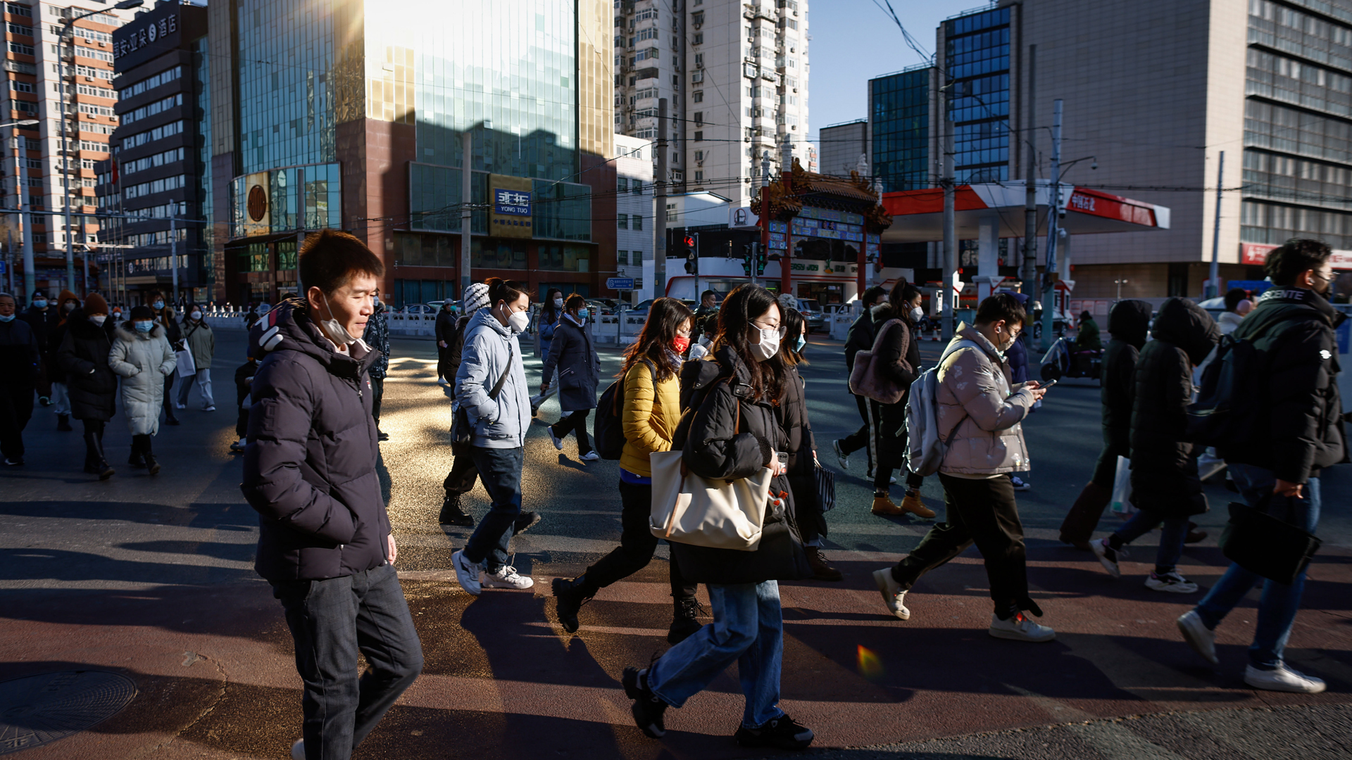 Menschen mit Gesichtsmasken gehen durch das Geschäftsviertel von Peking | EPA