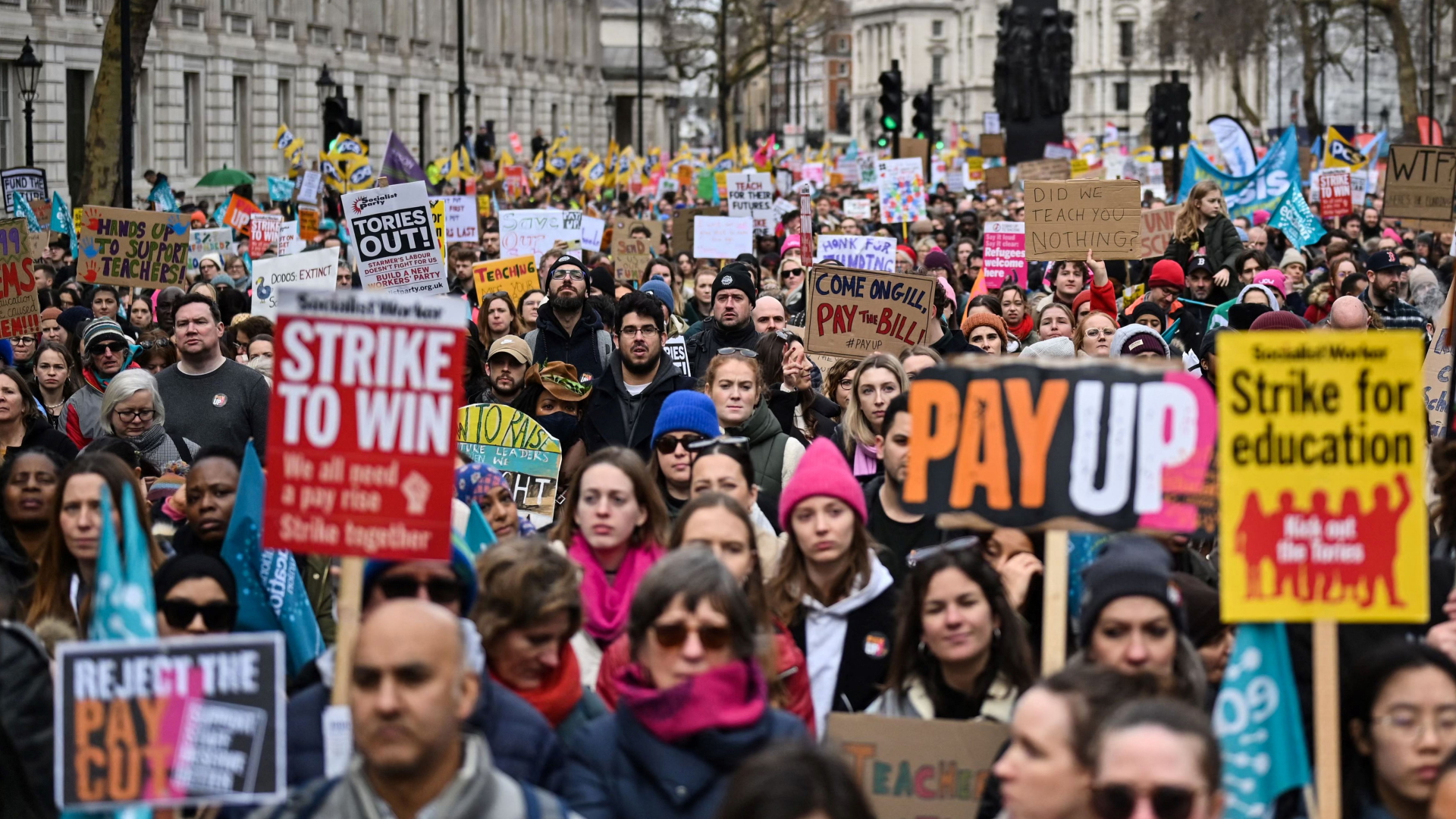 Lehrer protestieren auf einer Demo in London mit Plakaten und Schildern für höhere Löhne.