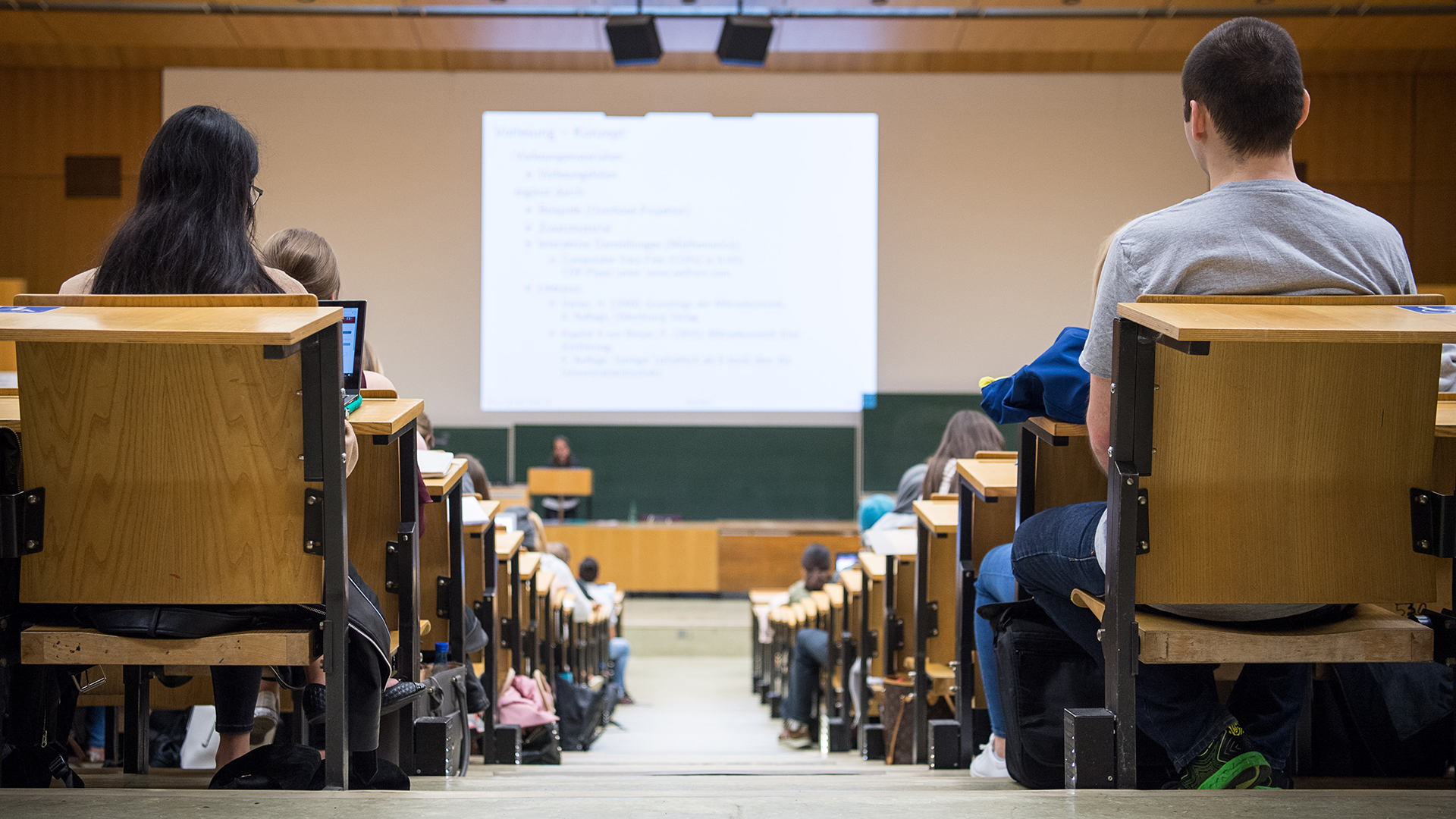 Studentinnen und Studenten sitzen während einer Vorlesung in einem Hörsaal. | dpa